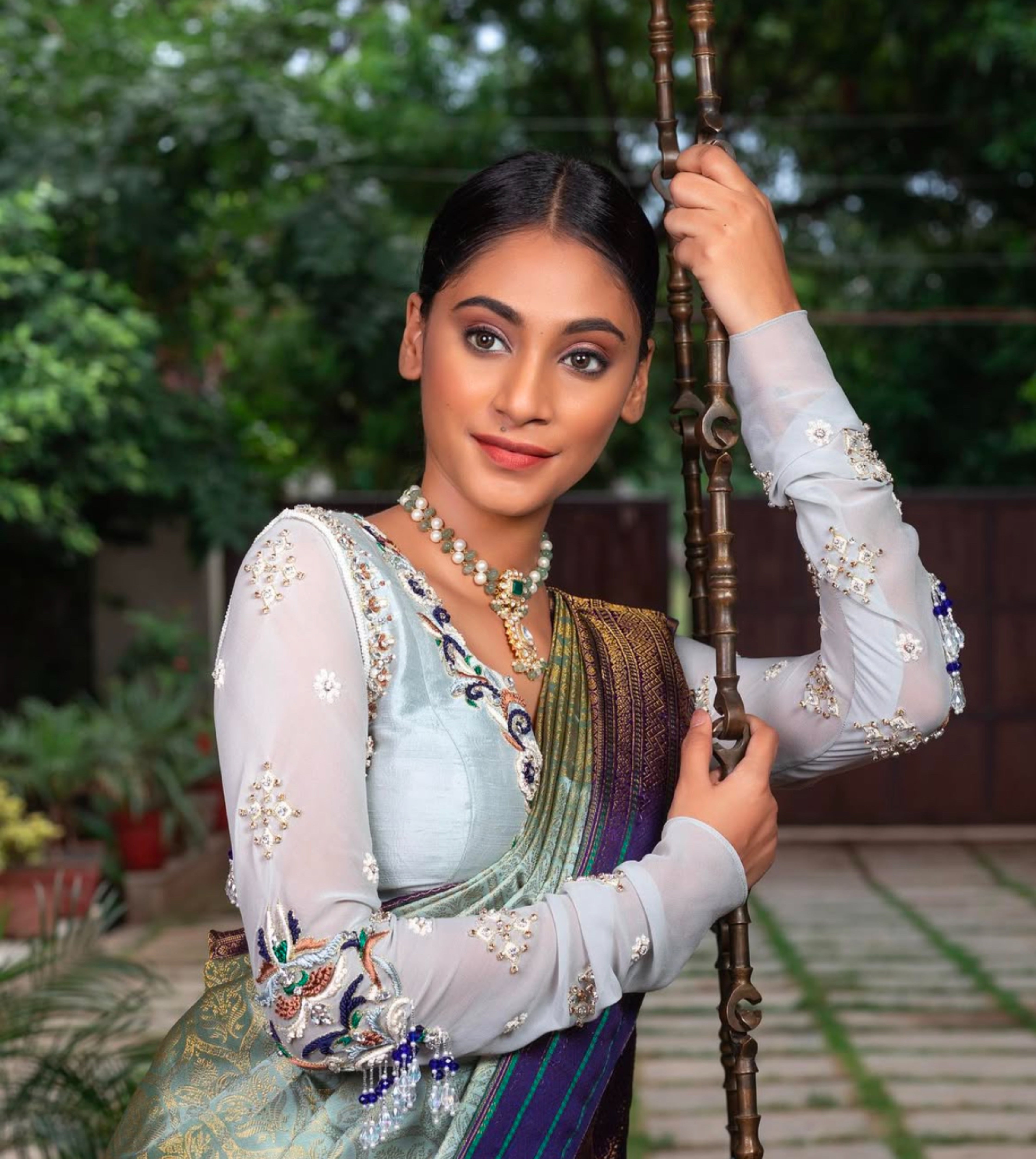 Miss India and Actress Anukreethy Vas on the swing in a raw silk and georgette backless blouse, intricately handcrafted by team Archana Karthick.
