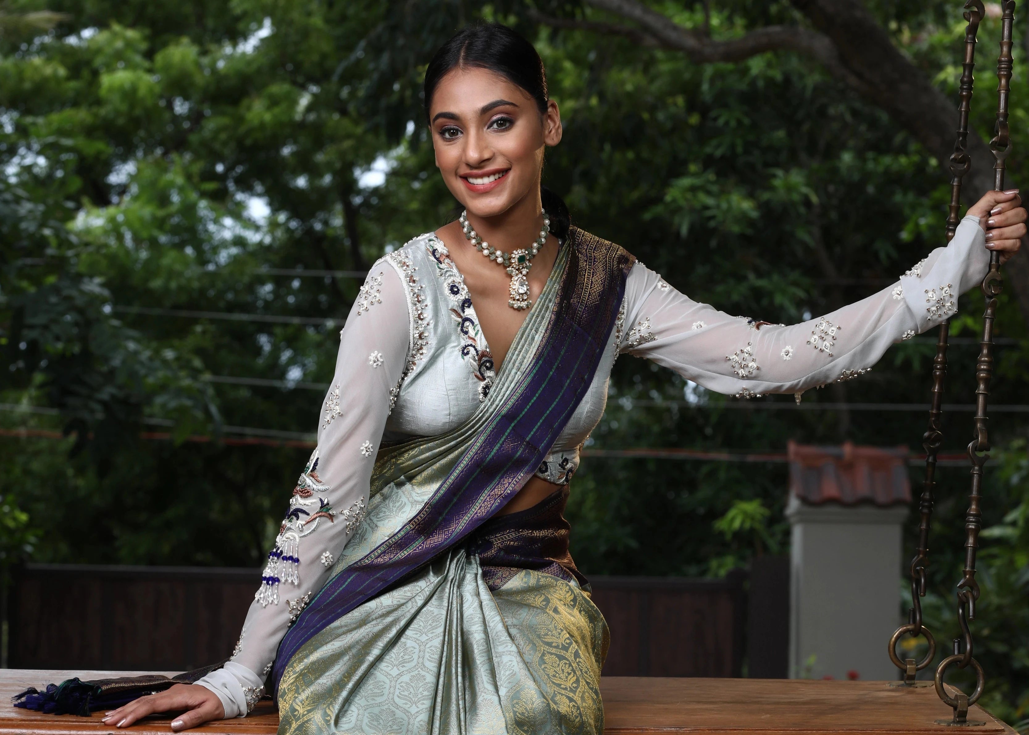 Miss India and Actress Anukreethy Vas posing in a raw silk and georgette backless blouse, intricately handcrafted by team Archana Karthick.