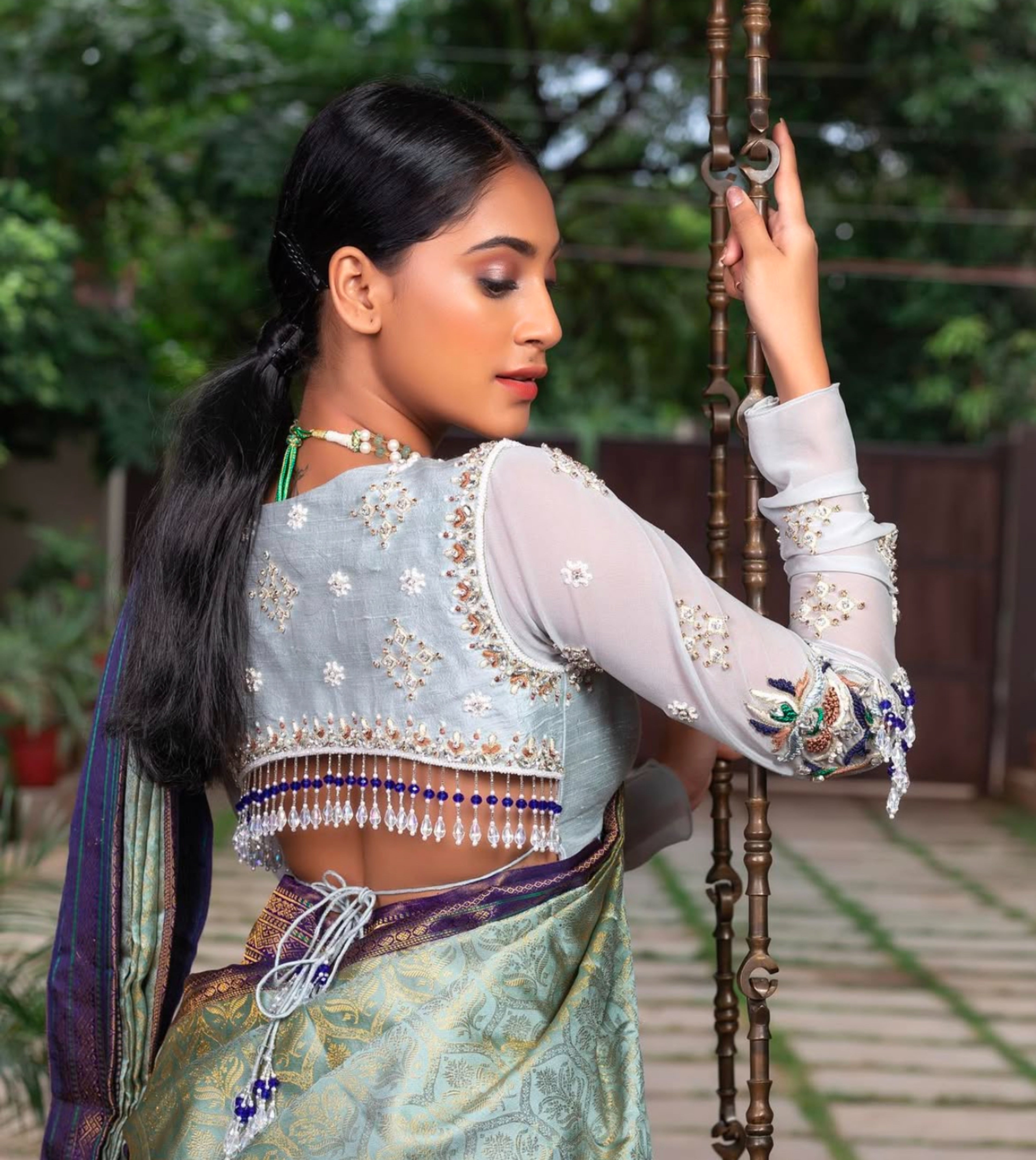 Miss India and Actress Anukreethy Vas showcasing the back blouse design in a raw silk and georgette backless blouse, intricately handcrafted by team Archana Karthick.