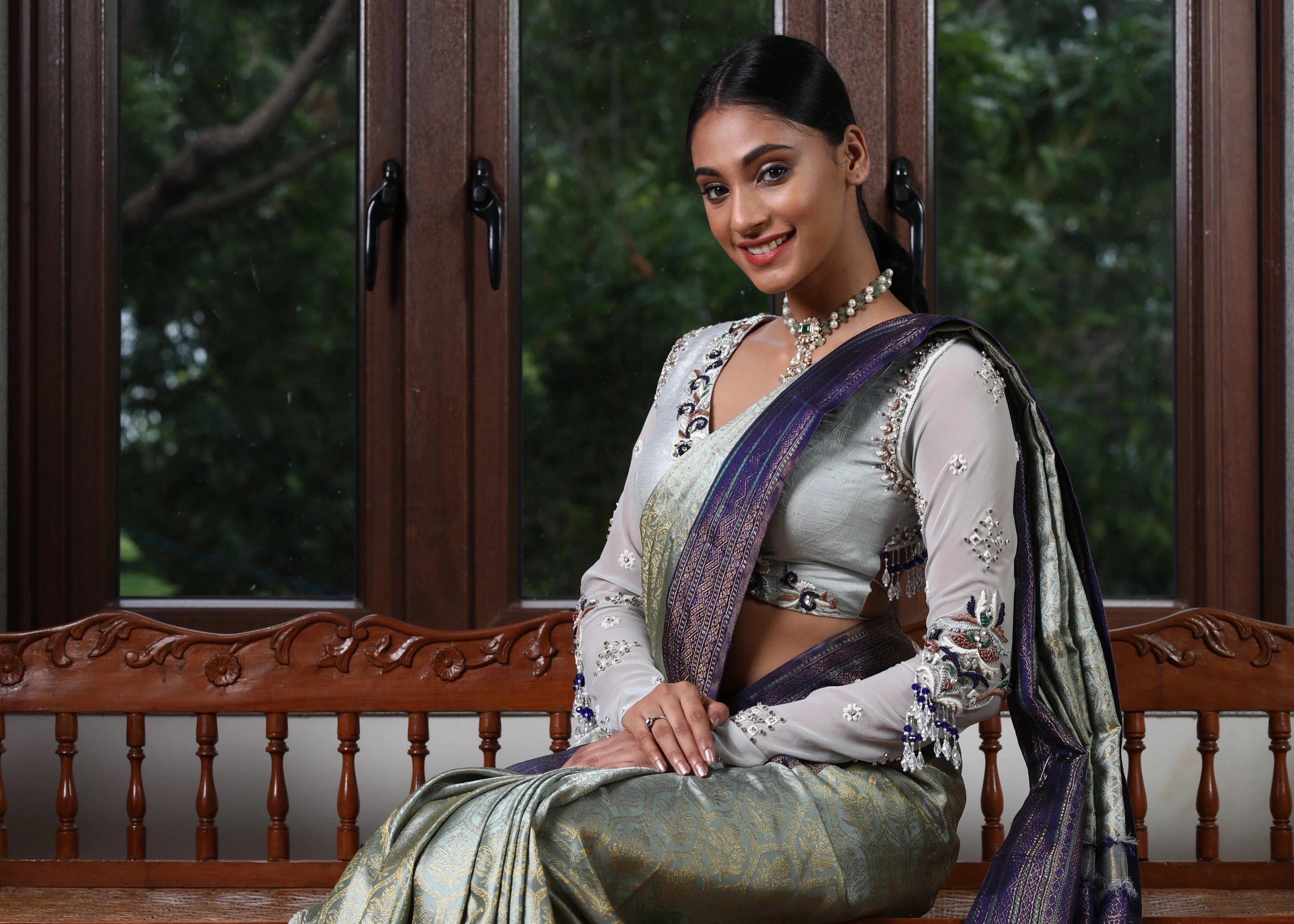 Miss India and Actress Anukreethy Vas smiling in a raw silk and georgette backless blouse, intricately handcrafted by team Archana Karthick.