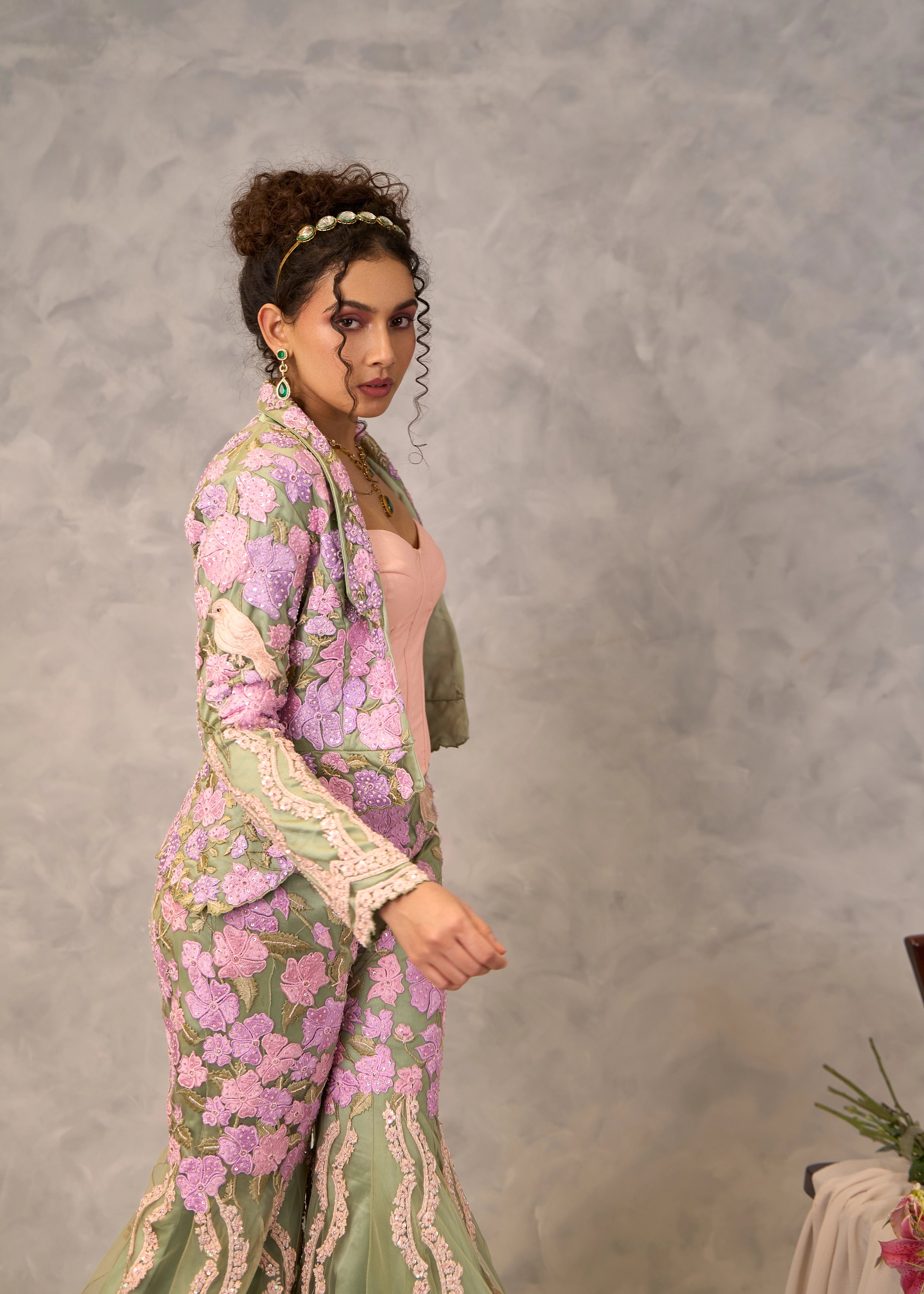 Model Keryn Justina Roy poses in a sage green sharara and jacket with pink corset. Perfect party look.