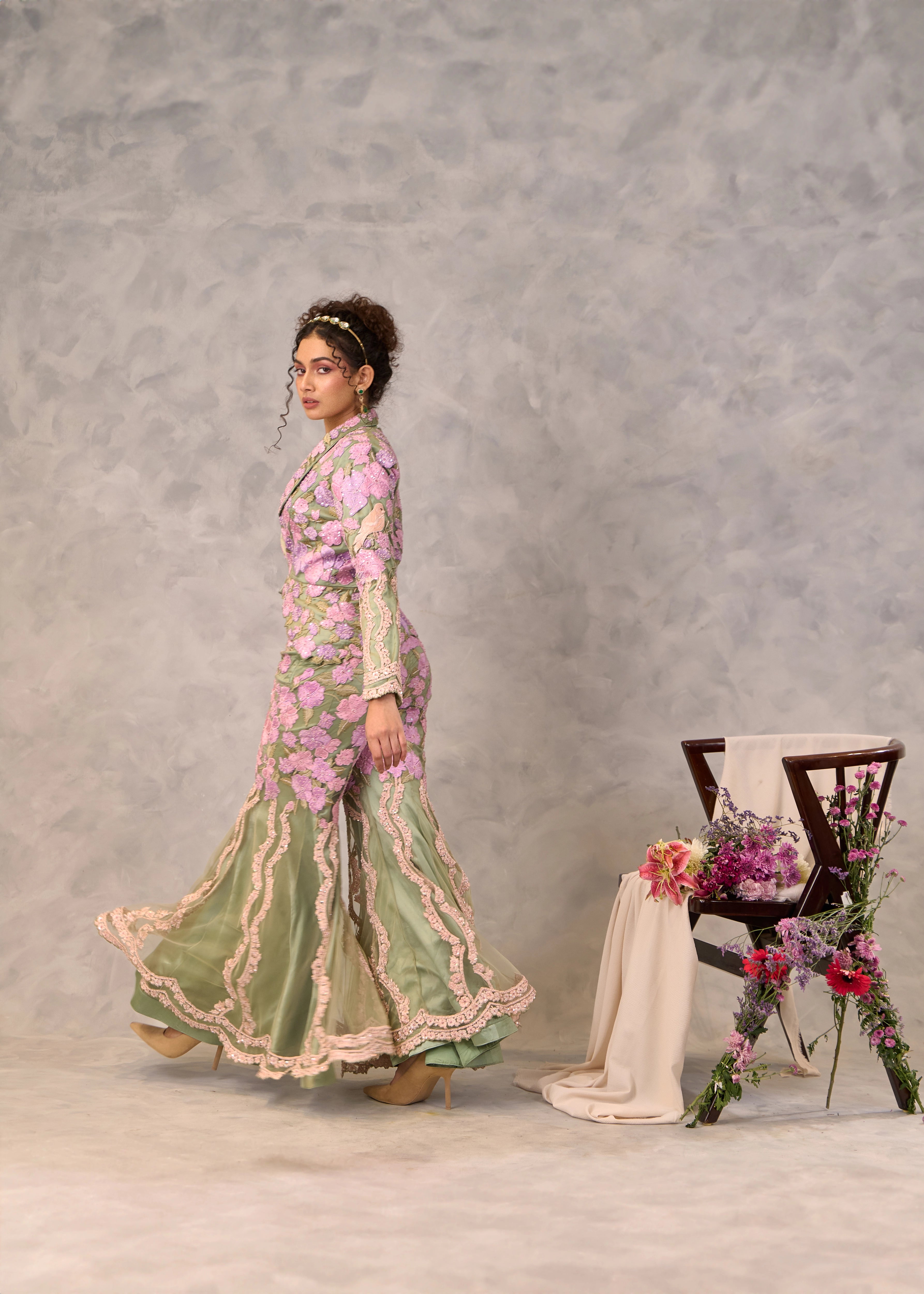 Model Keryn Justina Roy posing in a sage green sharara and jacket with pink corset. Perfect party look.