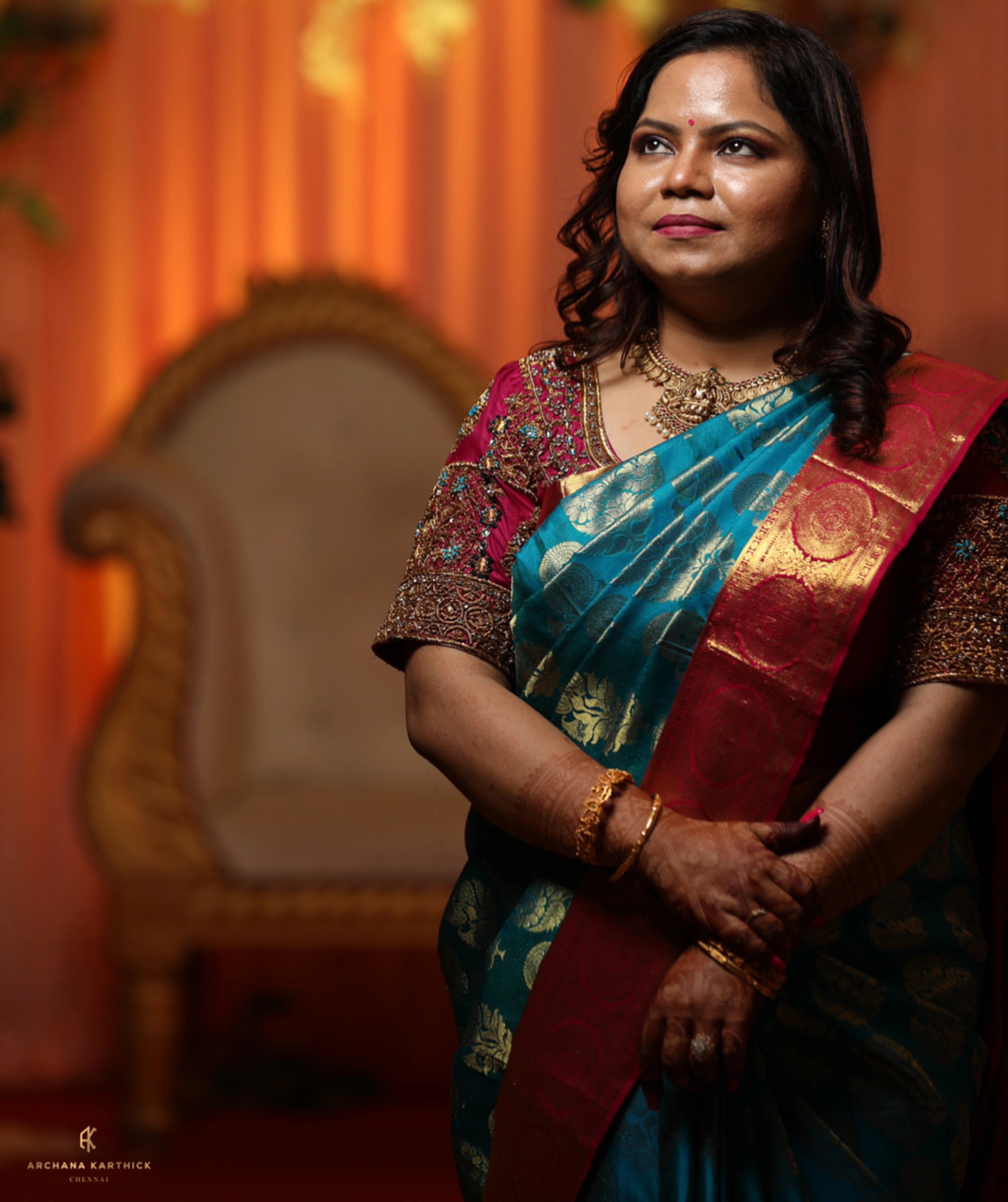 Model Adyasha smiling in a magenta silk blouse designed by Archana Karthick