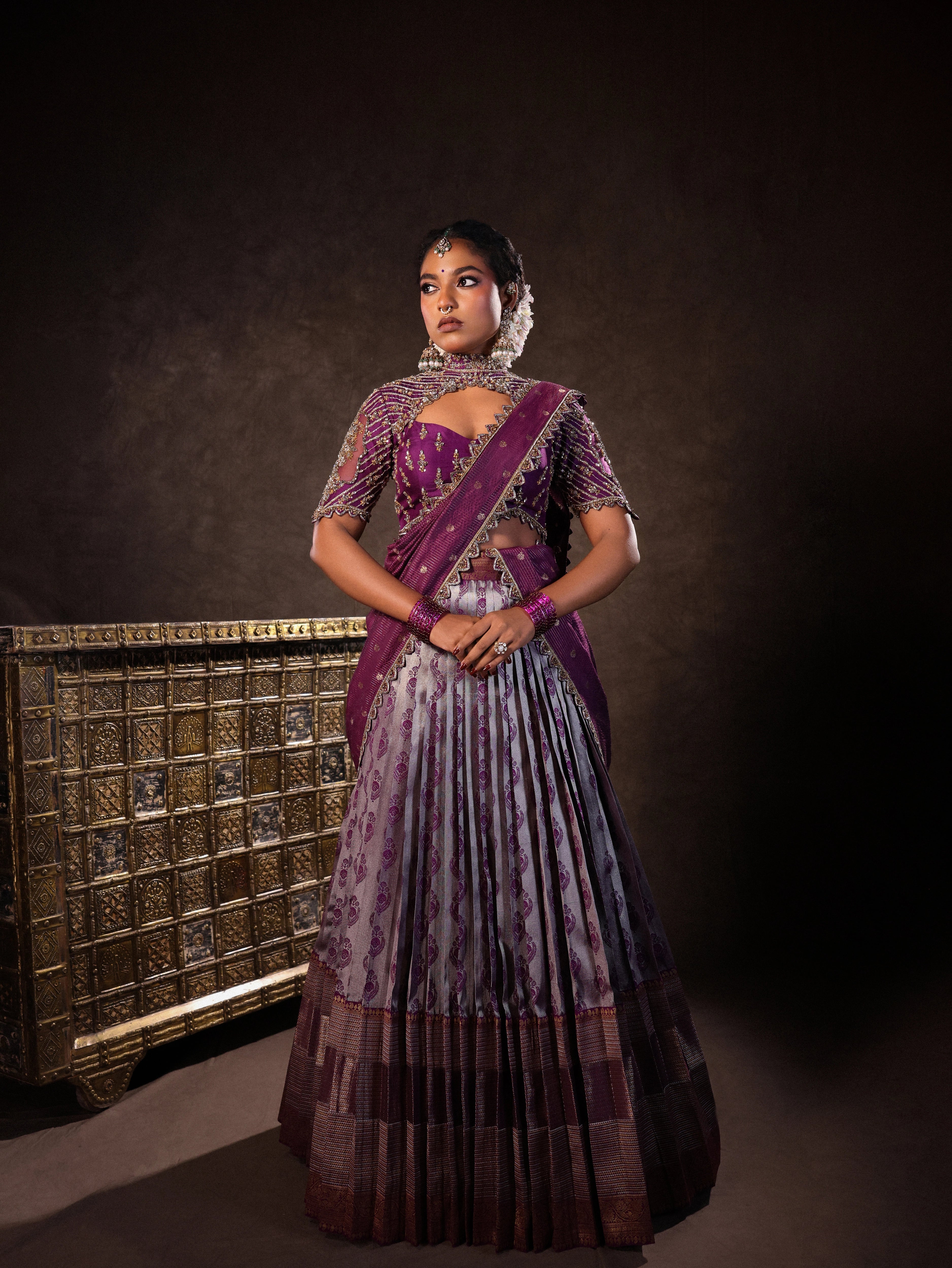 Model Ashika Crystal in a silk half saree set in purple, handcrafted with zardozi, sequins and rhinestones. Team Archana Karthick completed the style with purple glass bangles, a ring, jhumkas, nose ring and a maang tikka.