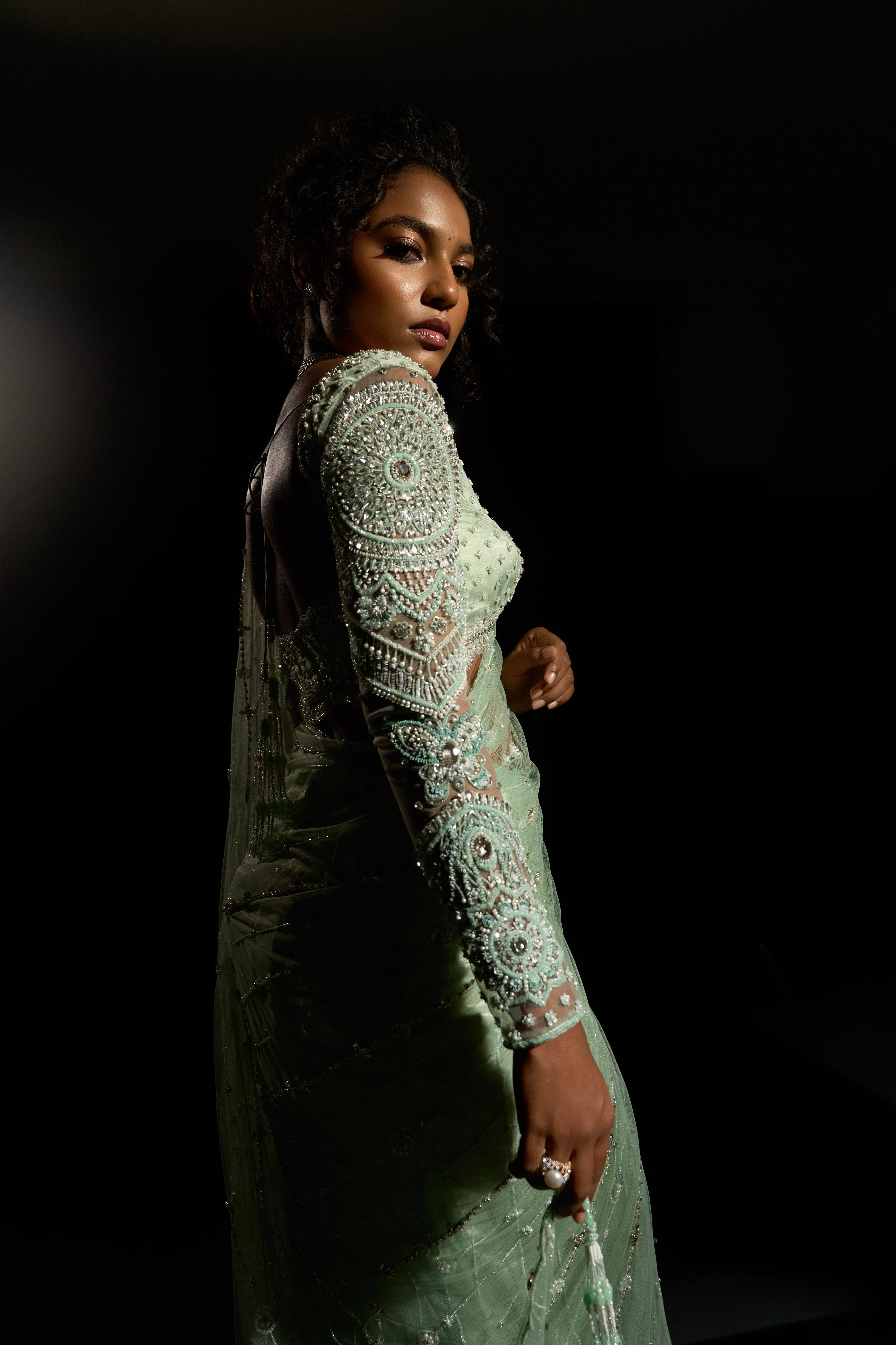 Model Ashika Crystal posing for the sleeve detailing in a green saree set intricately adorned with sequins, rhinestones, crystals and cutdana for "STARDUST" - A/W'25 saree collection by team Archana Karthick.