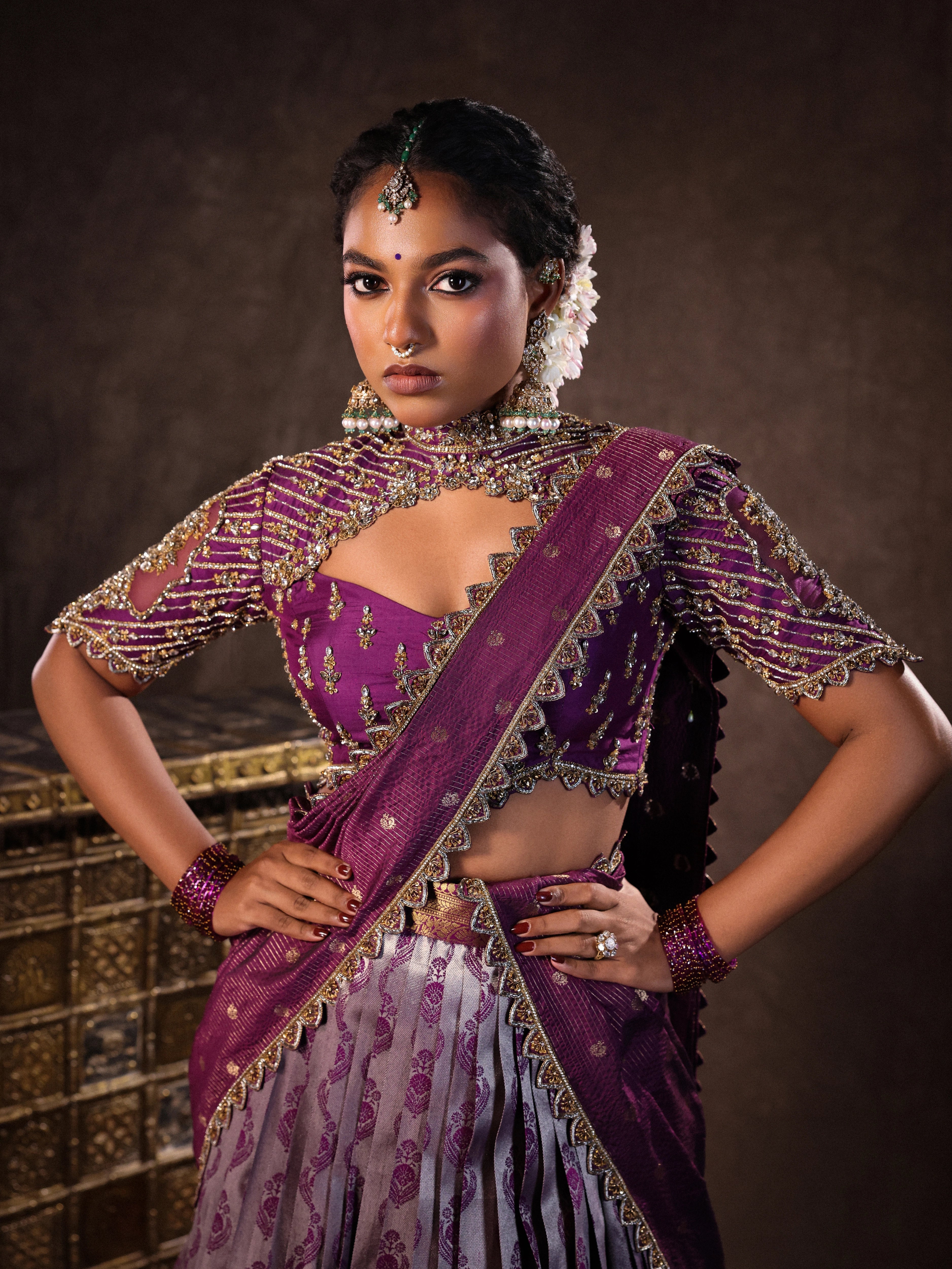 Model Ashika Crystal posing in a silk half saree set in purple, handcrafted with zardozi, sequins and rhinestones. Team Archana Karthick completed the style with purple glass bangles, a ring, jhumkas, nose ring and a maang tikka.