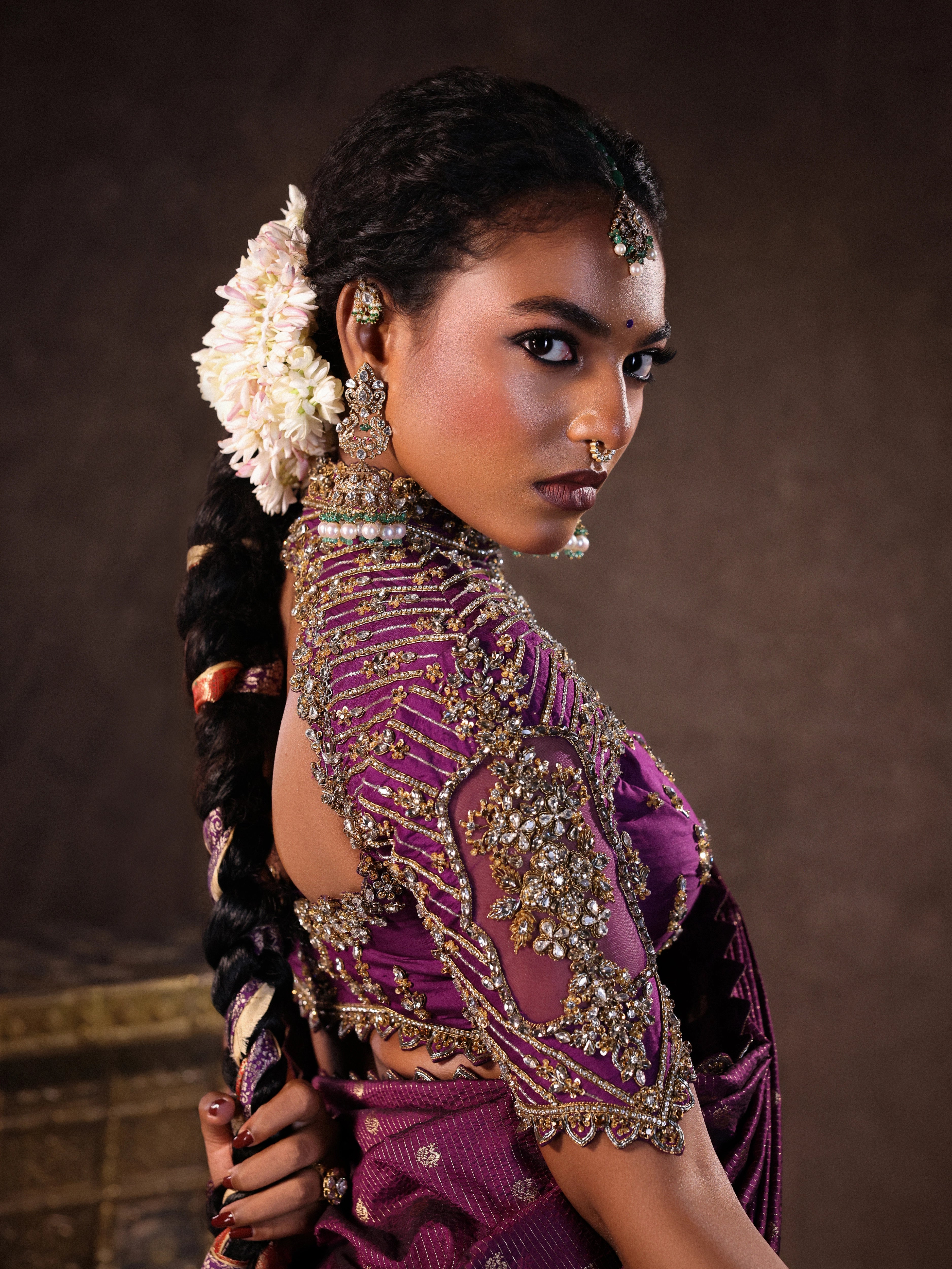 Model Ashika Crystal showcasing sleeve and back design in a silk half saree set in purple, handcrafted with zardozi, sequins and rhinestones. Team Archana Karthick completed the style with purple glass bangles, a ring, jhumkas, nose ring and a maang tikka.