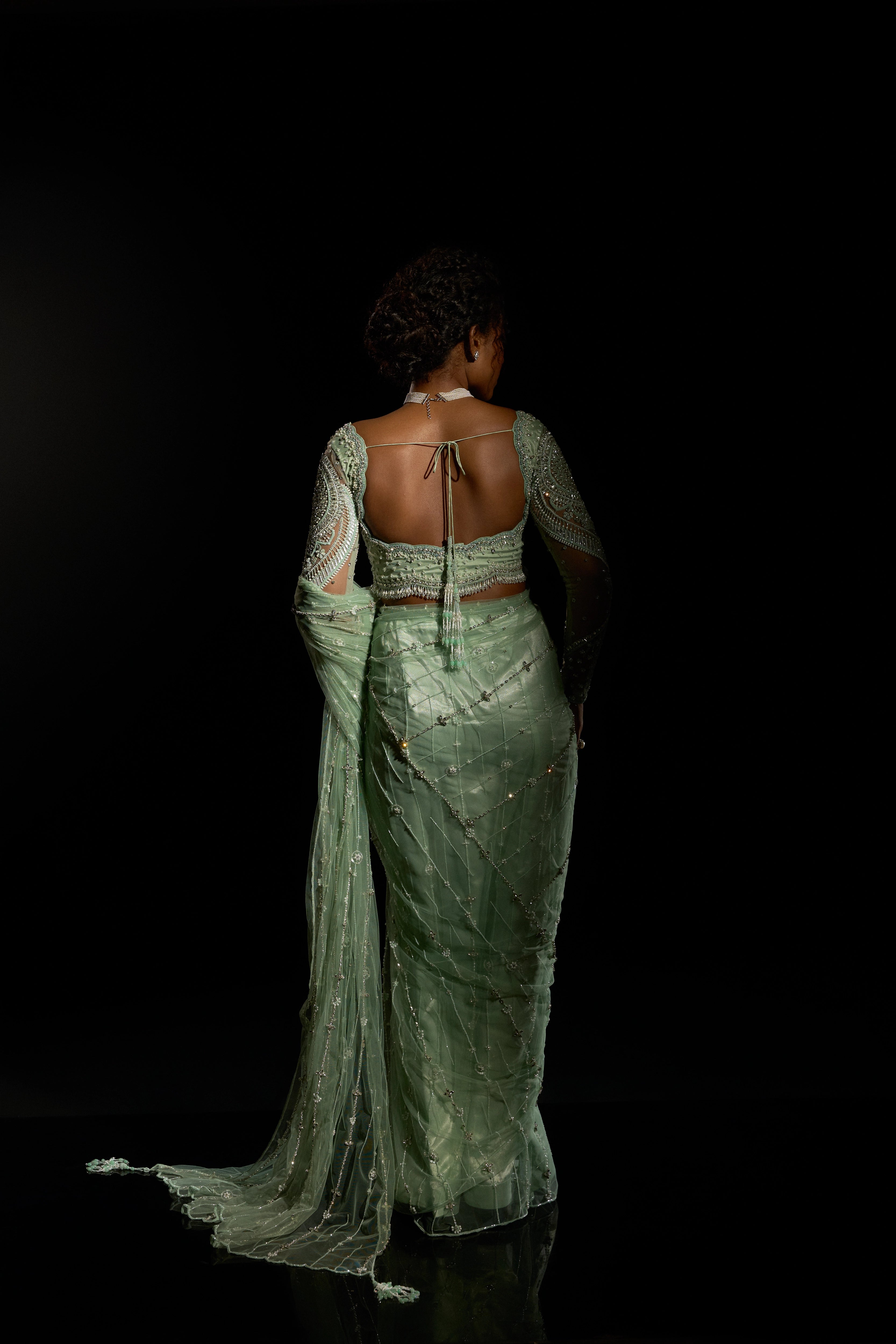 Model Ashika Crystal striking a pose for back design detailing in a green saree set intricately adorned with sequins, rhinestones, crystals and cutdana for "STARDUST" - A/W'25 saree collection by team Archana Karthick.