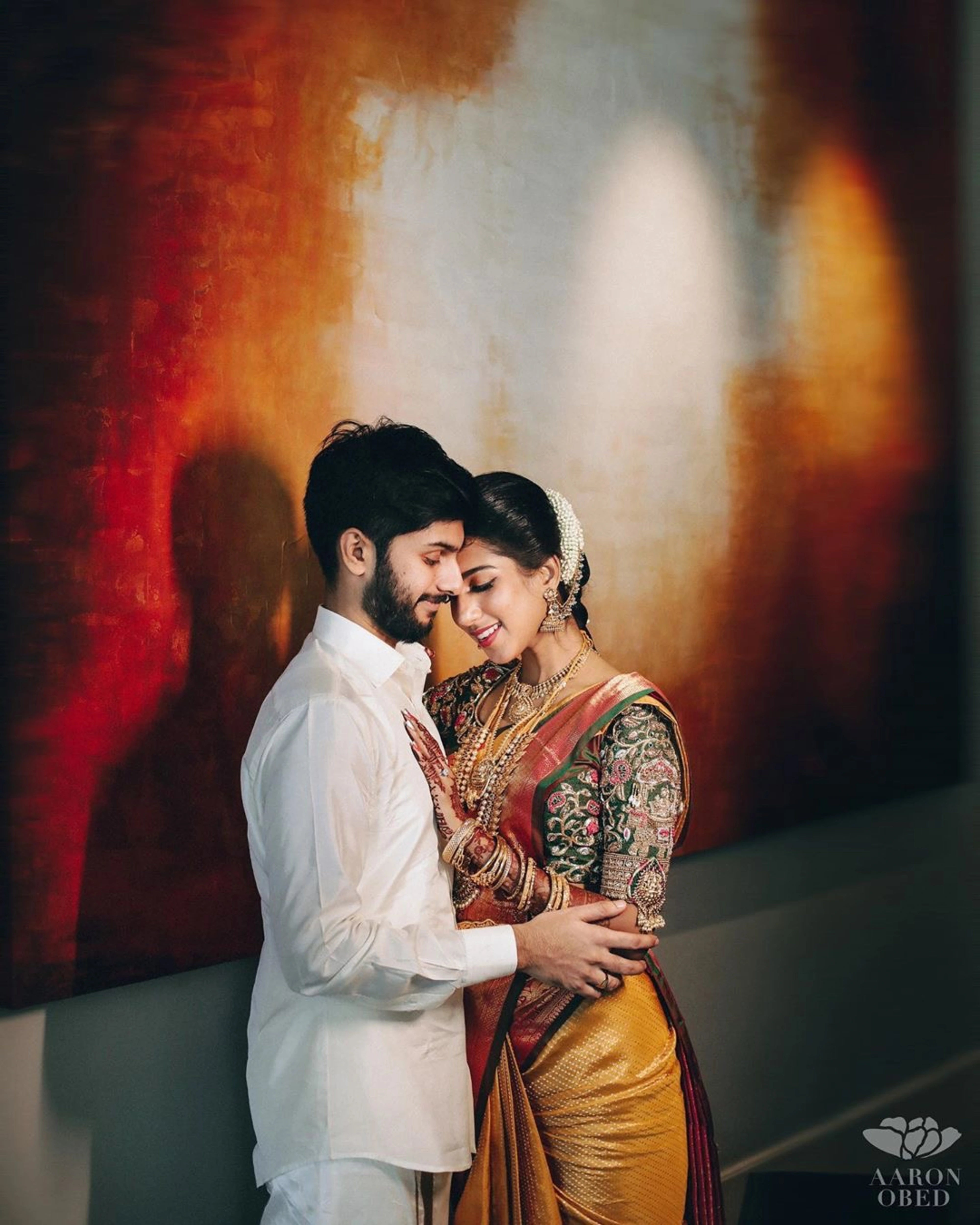 Model Ashwini Kumar smiling in a green silk blouse for her wedding with Kavin Venkatesh of Maybell, handcrafted intricately with stones, pearls, zardozi, beads, zari and knot work by team Archana Karthick.