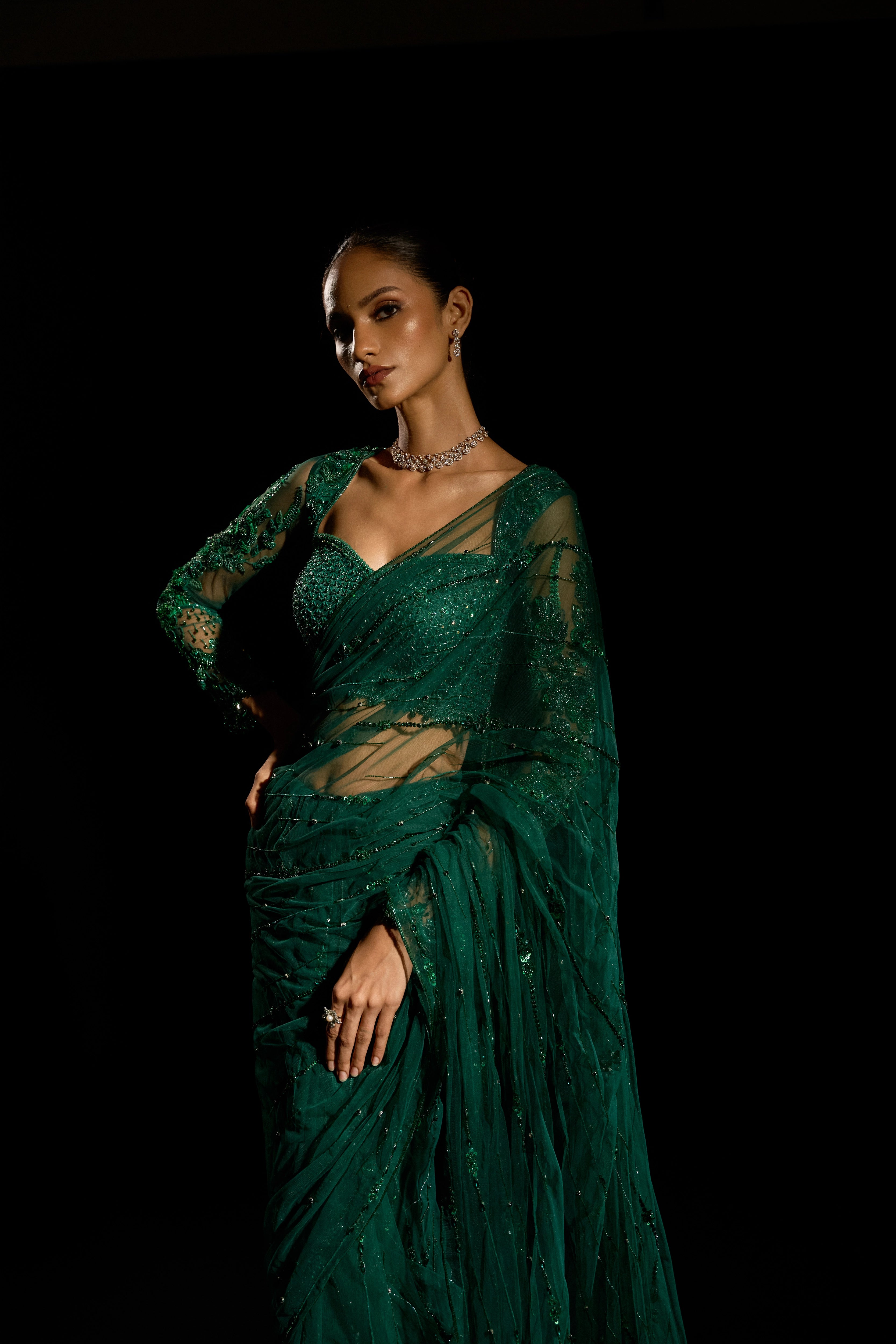Model Esha Gohil during a photoshoot in a bottle green saree set is intricately adorned with sequins, rhinestones, crystals and cutdana for "STARDUST" - A/W'25 saree collection by team Archana Karthick.