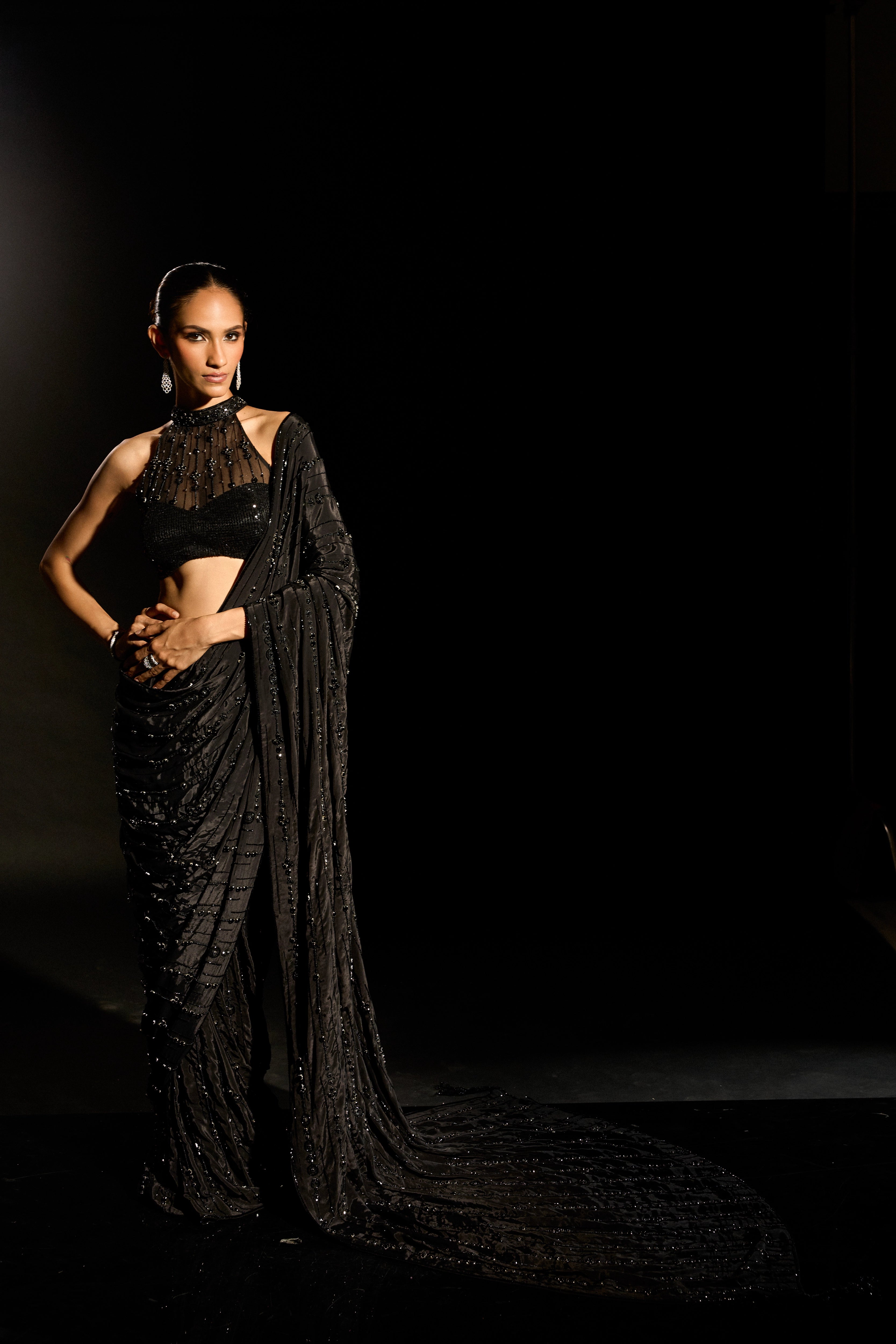 Model Esha Gohil in a black saree set is intricately adorned with sequins, rhinestones and cutdana for "STARDUST" - A/W'25 saree collection by team Archana Karthick.