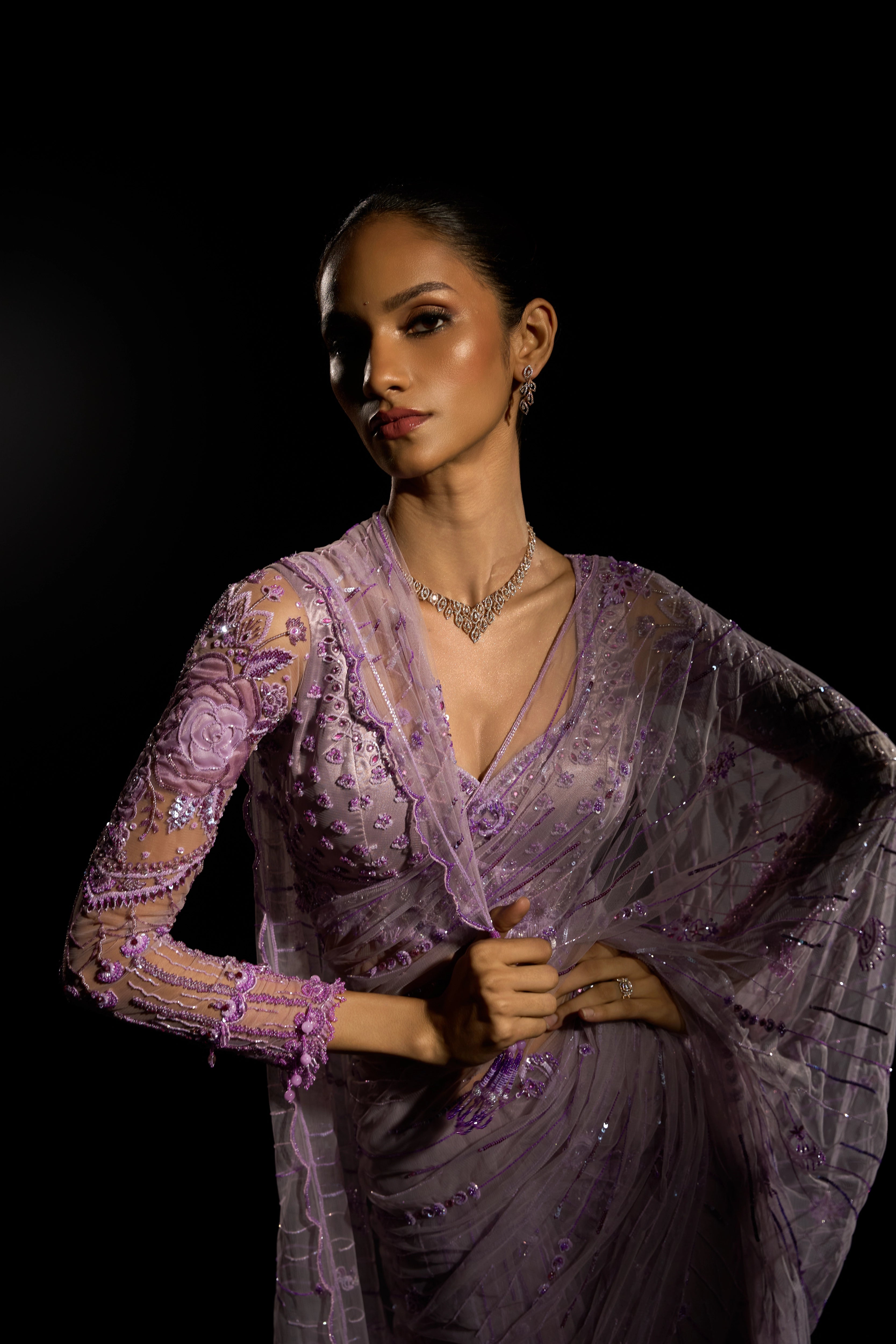 Model Esha Gohil posing for sleeve design in a lavender saree set intricately adorned with sequins, rhinestones, crystals and cutdana for "STARDUST" - A/W'25 saree collection by team Archana Karthick.