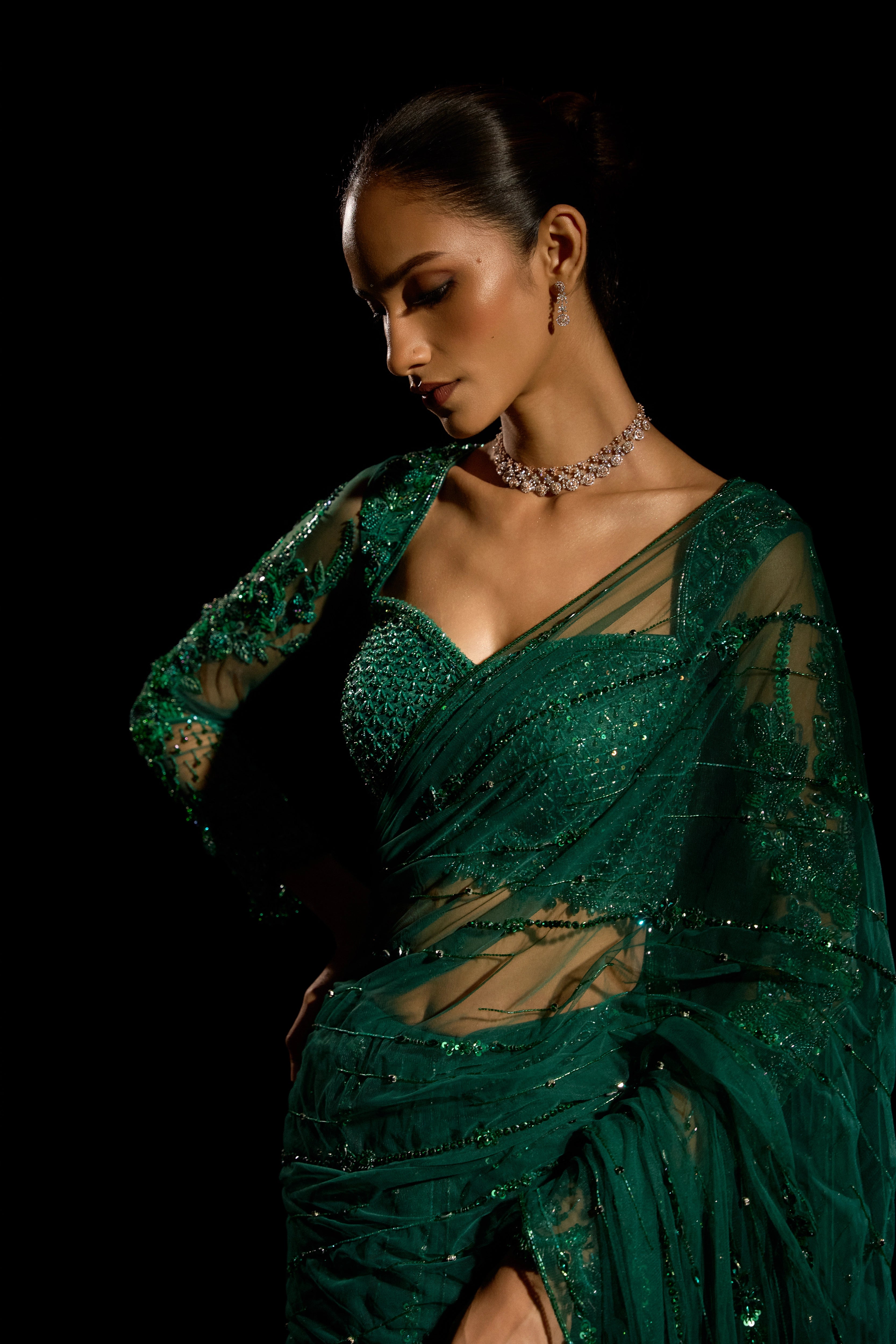 Model Esha Gohil posing in a bottle green saree set is intricately adorned with sequins, rhinestones, crystals and cutdana for "STARDUST" - A/W'25 saree collection by team Archana Karthick.