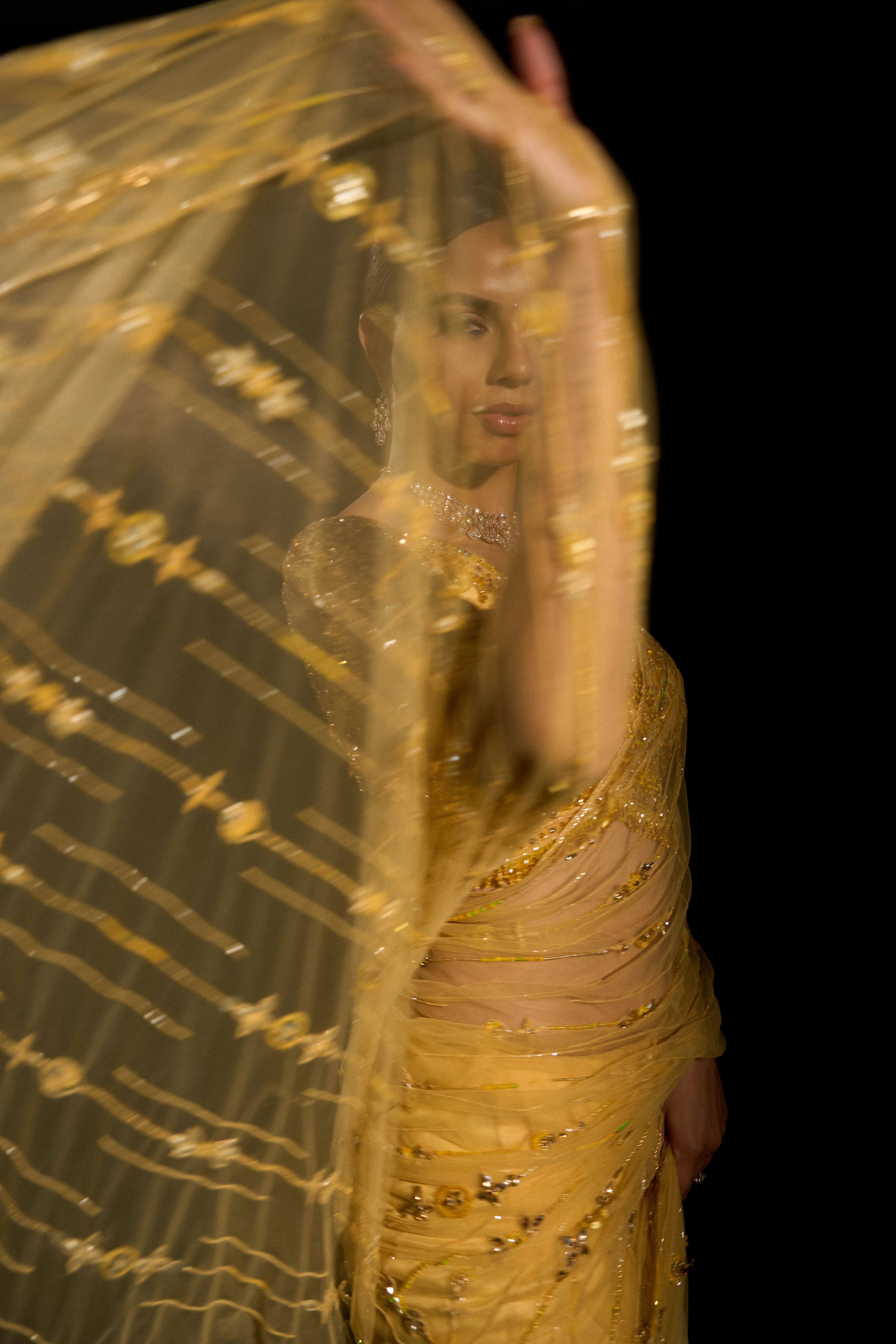 Model Jane C Thompson helping capture the intricacy in a yellow saree set intricately adorned with sequins, rhinestones, crystals and cutdana for "STARDUST" - A/W'25 saree collection by team Archana Karthick.