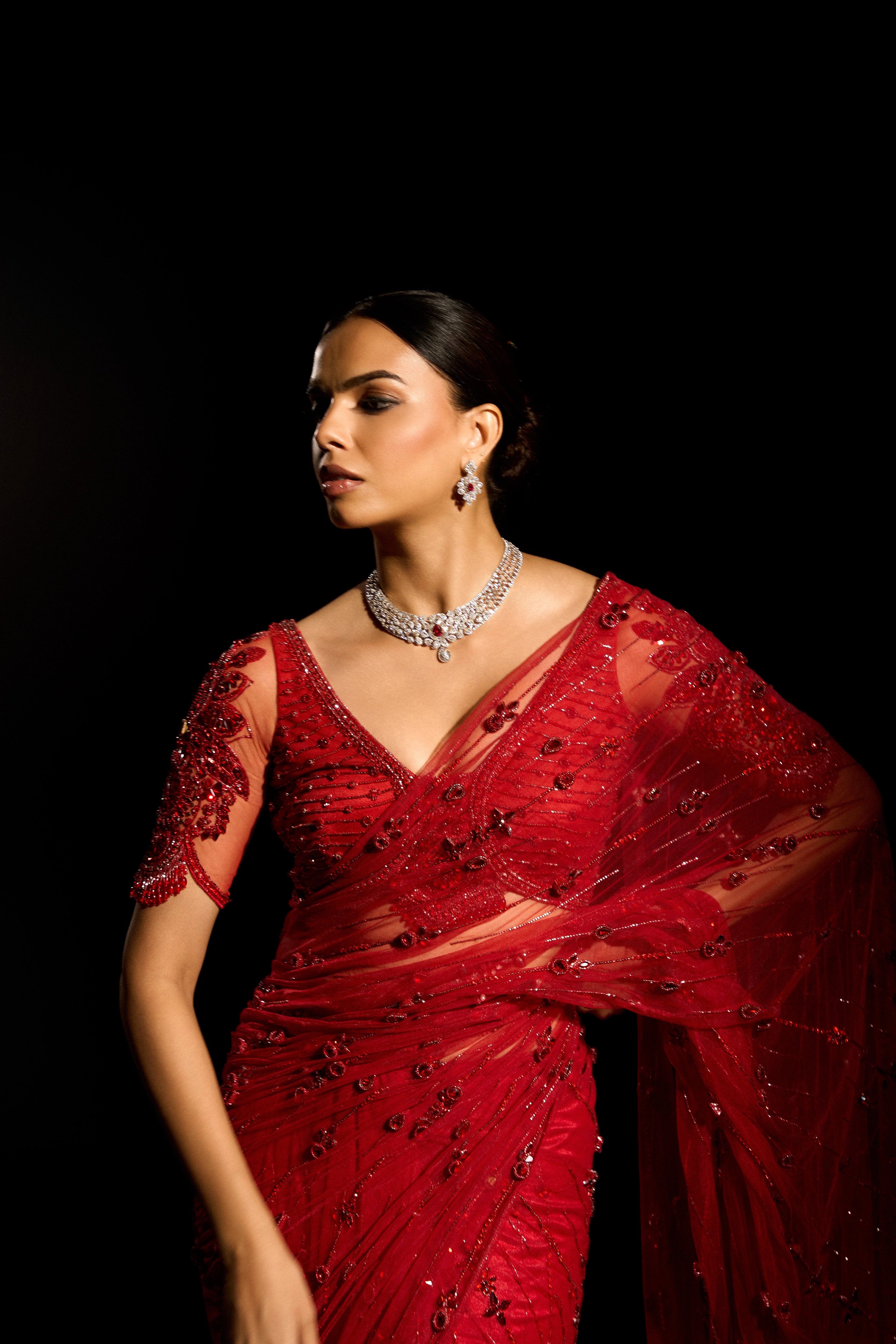 Model Jane C Thompson in a red saree set intricately adorned with sequins, rhinestones, crystals and cutdana for "STARDUST" - A/W'25 saree collection by team Archana Karthick.