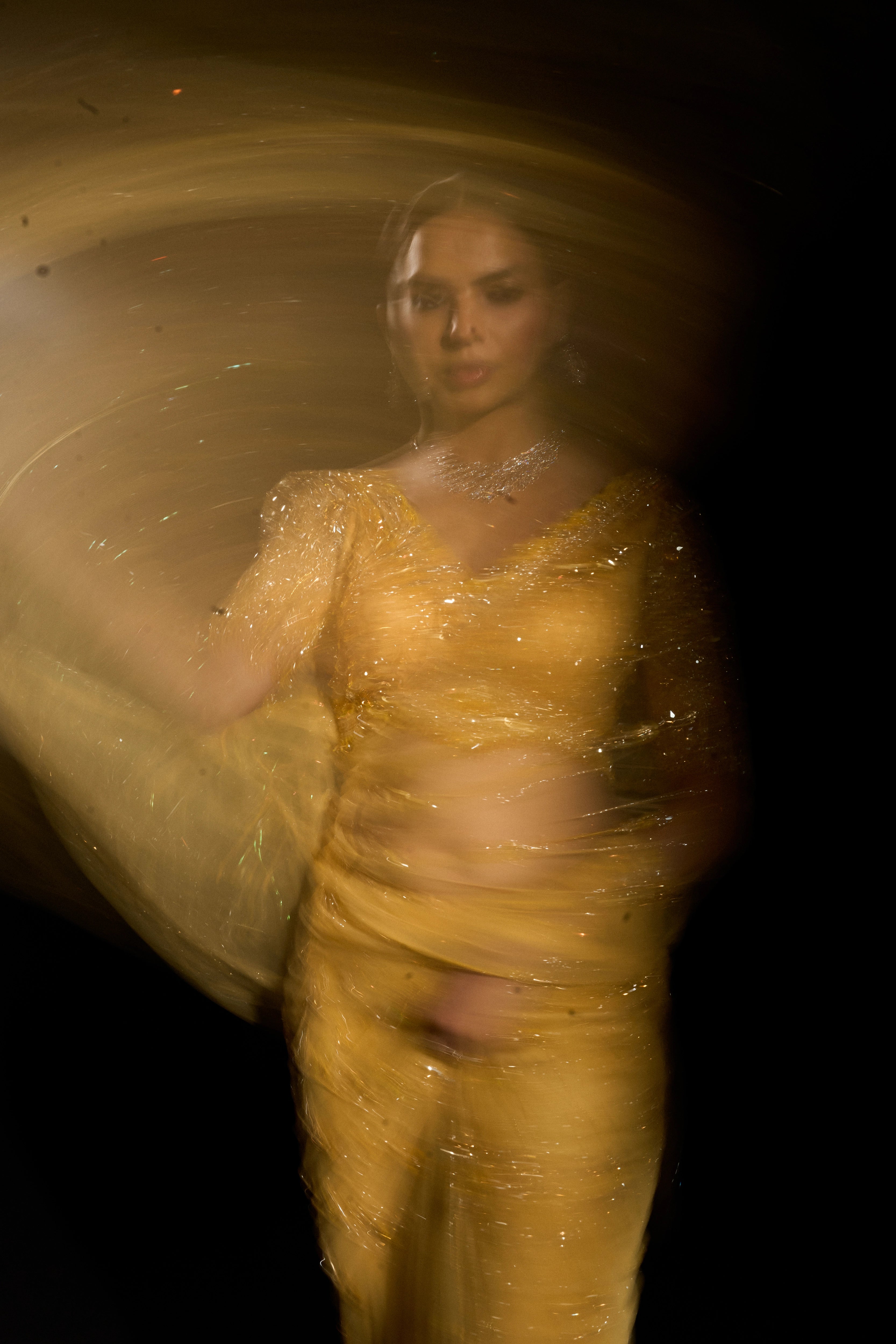 Model Jane C Thompson posing during photoshoot in a yellow saree set intricately adorned with sequins, rhinestones, crystals and cutdana for "STARDUST" - A/W'25 saree collection by team Archana Karthick.