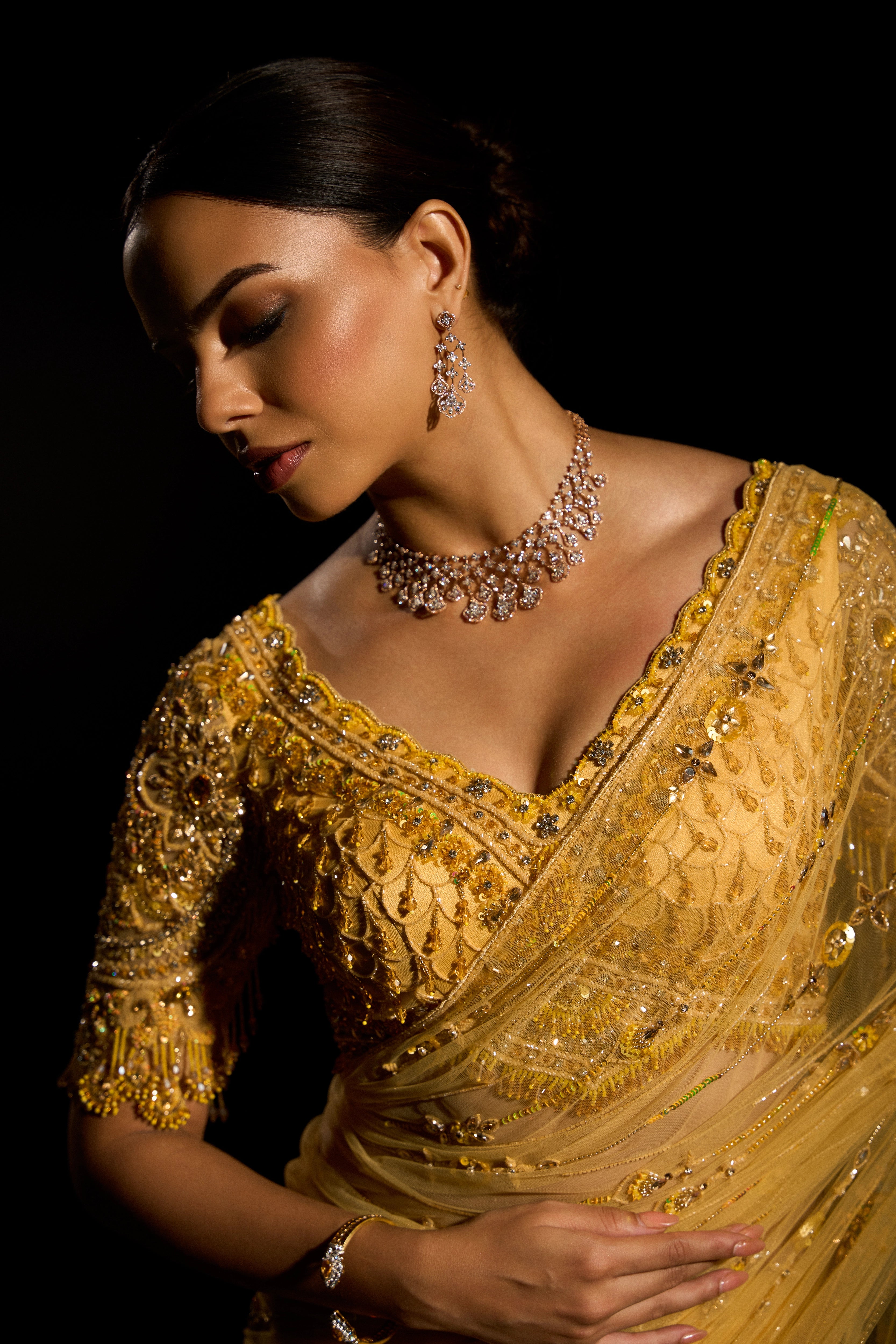 Model Jane C Thompson posing for blouse detailing in a yellow saree set intricately adorned with sequins, rhinestones, crystals and cutdana for "STARDUST" - A/W'25 saree collection by team Archana Karthick.