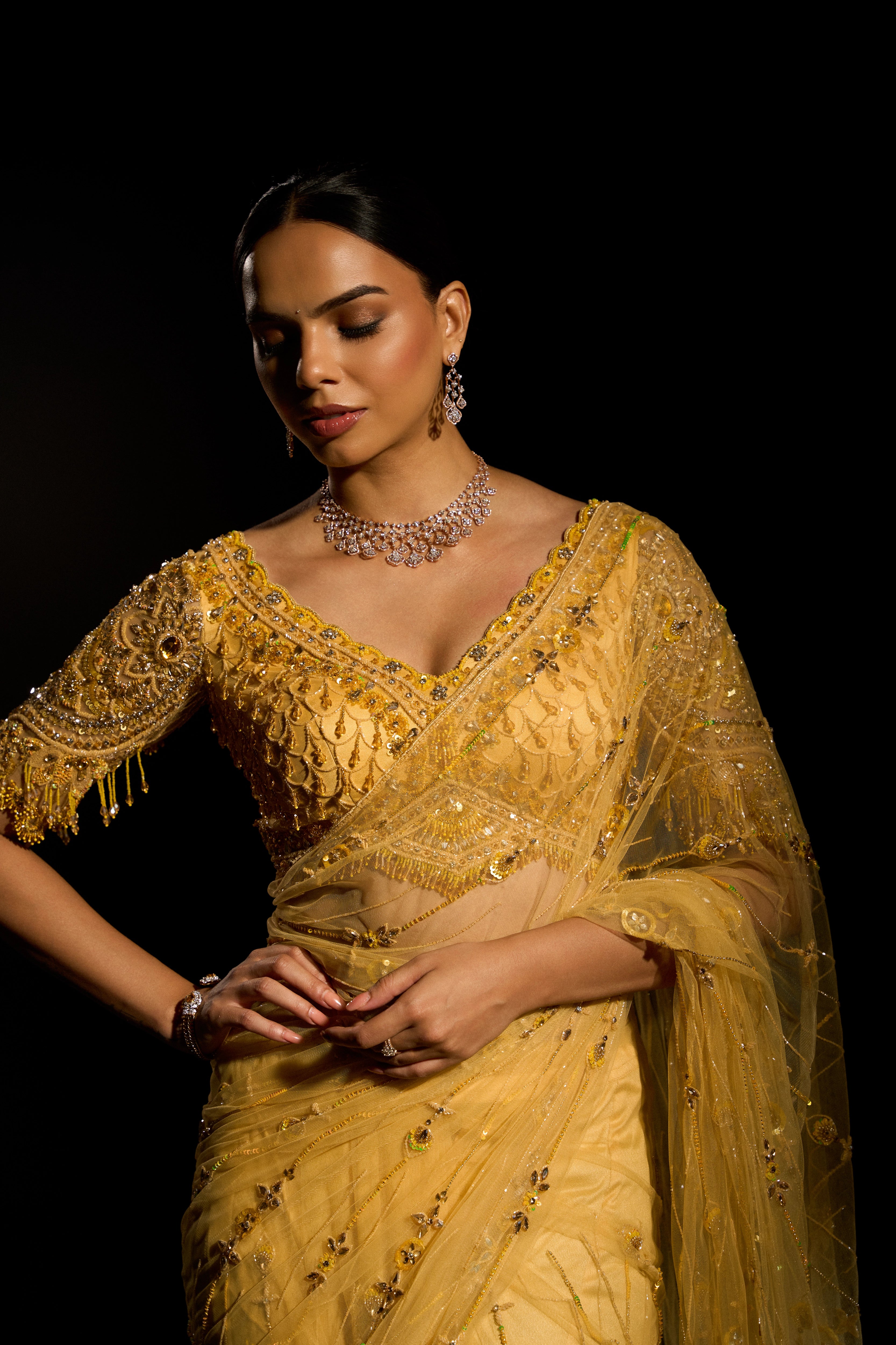 Model Jane C Thompson posing for front detailing in a yellow saree set intricately adorned with sequins, rhinestones, crystals and cutdana for "STARDUST" - A/W'25 saree collection by team Archana Karthick.