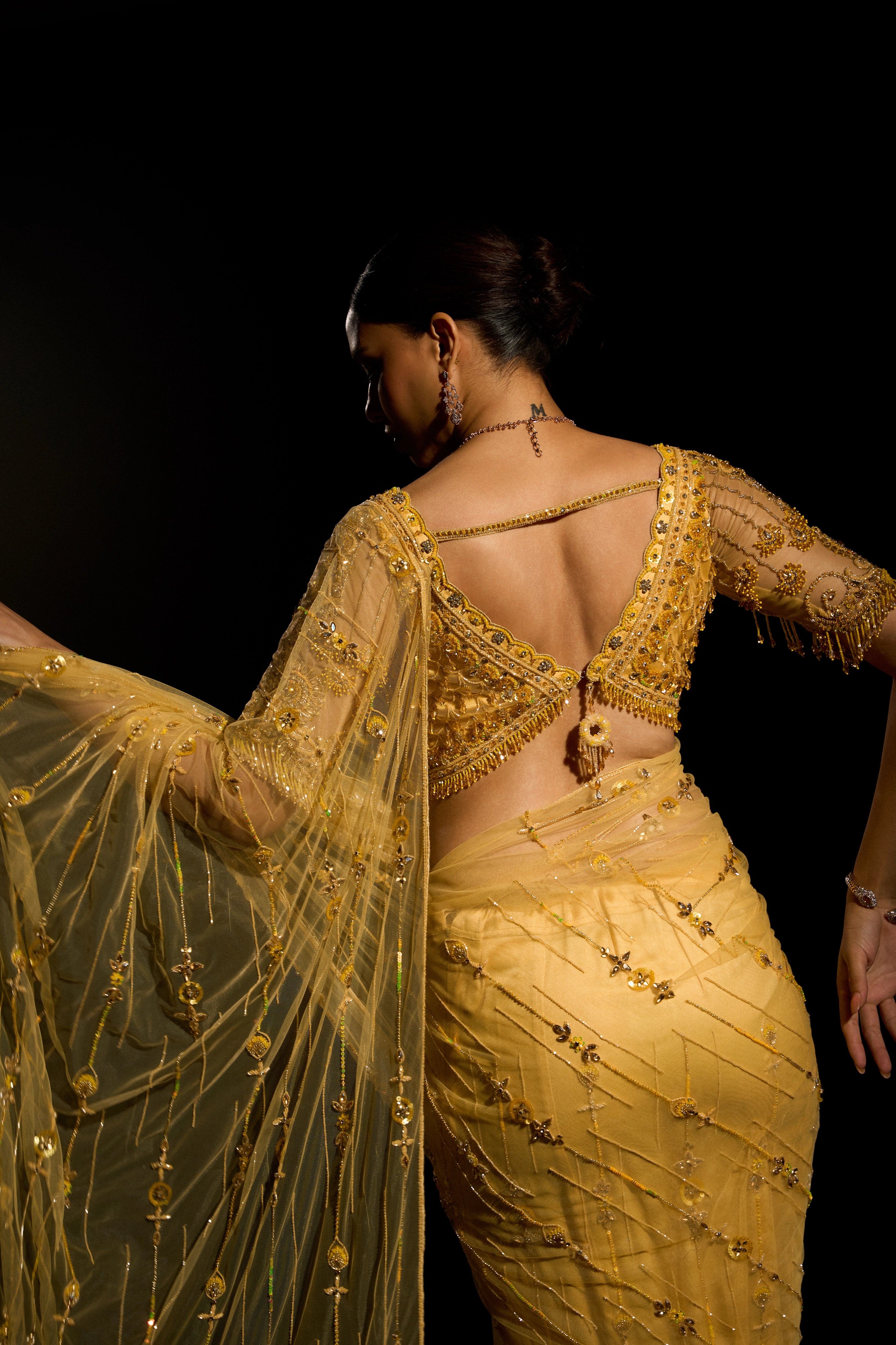 Model Jane C Thompson posing for photoshoot in a yellow saree set intricately adorned with sequins, rhinestones, crystals and cutdana for "STARDUST" - A/W'25 saree collection by team Archana Karthick.
