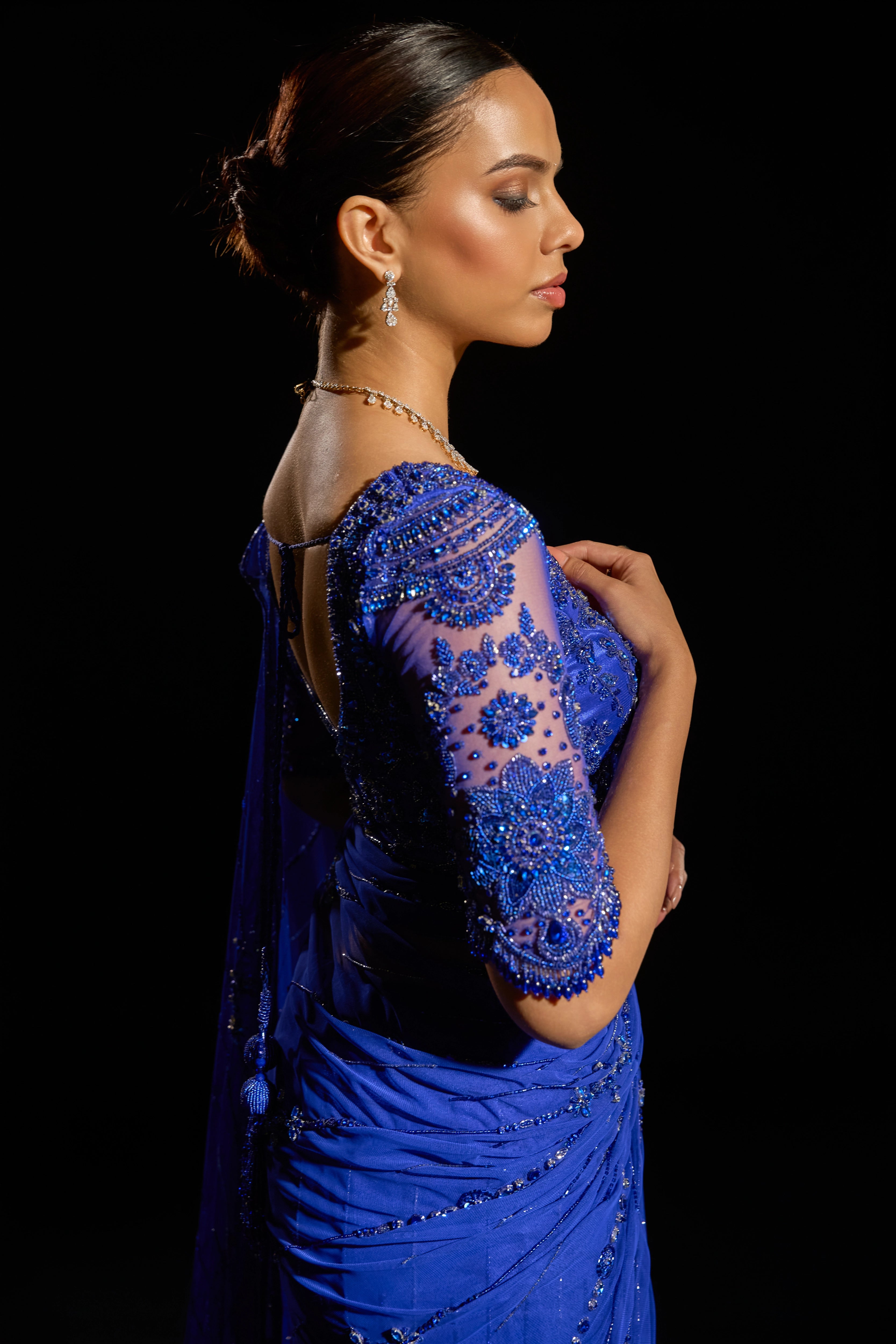 Model Jane C Thompson showcasing sleeve detailing in a sapphire blue saree set intricately adorned with sequins, rhinestones, crystals and cutdana for "STARDUST" - A/W'25 saree collection by team Archana Karthick.