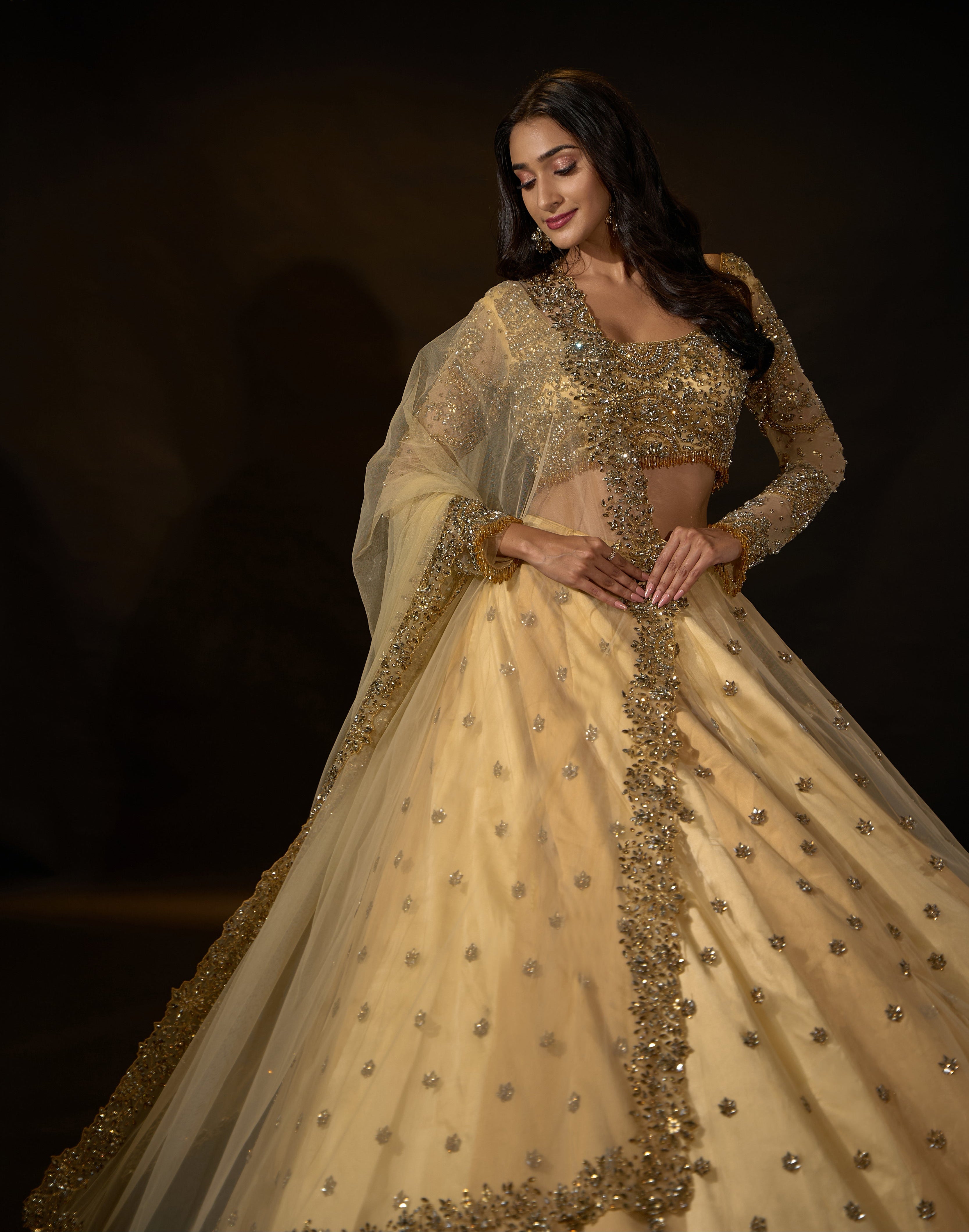 Model Rheyea in a golden beige lehnega by Archana Karthick smiling to her right