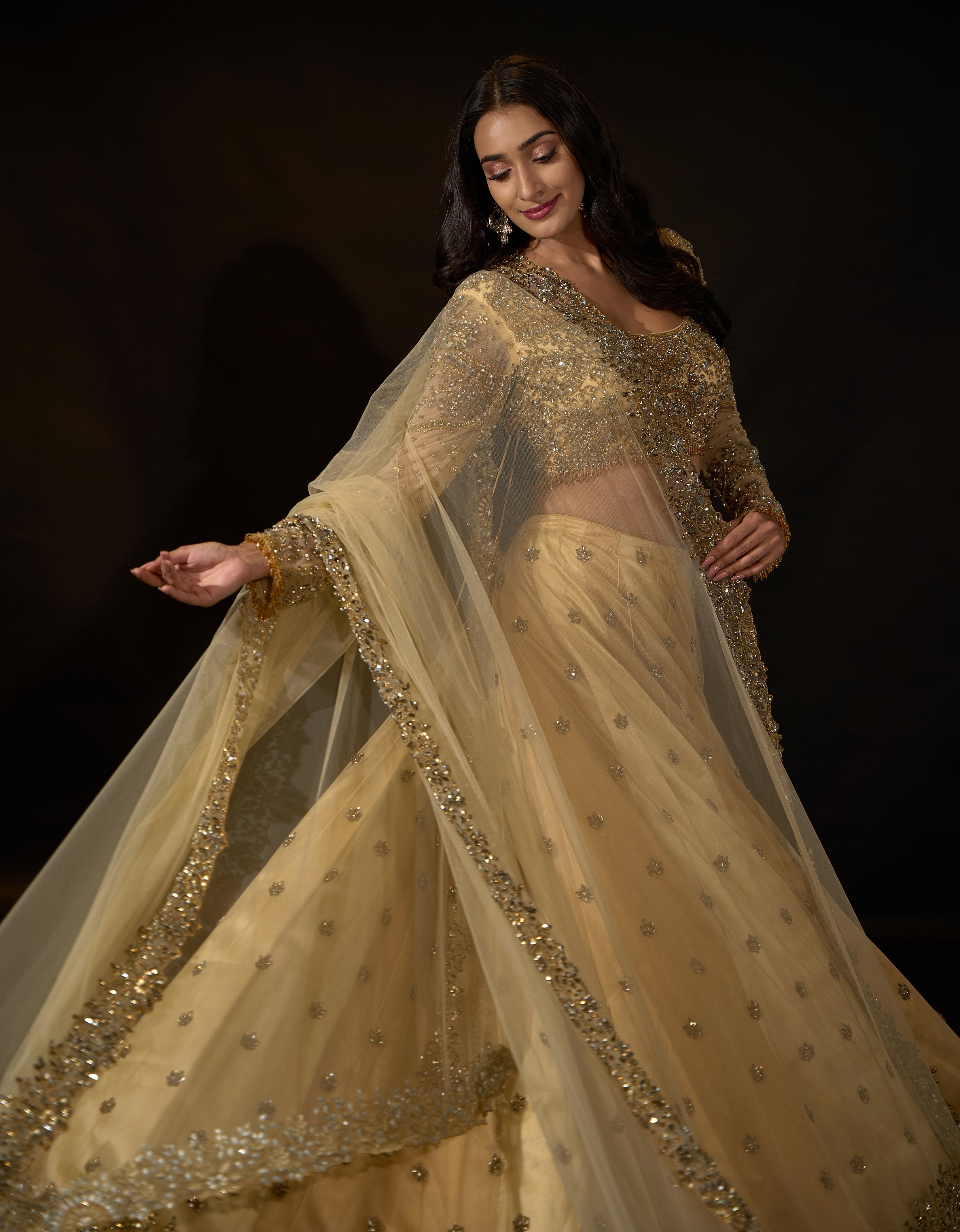 Model Rheyea in a golden beige lehnega by Archana Karthick twirling for the camera