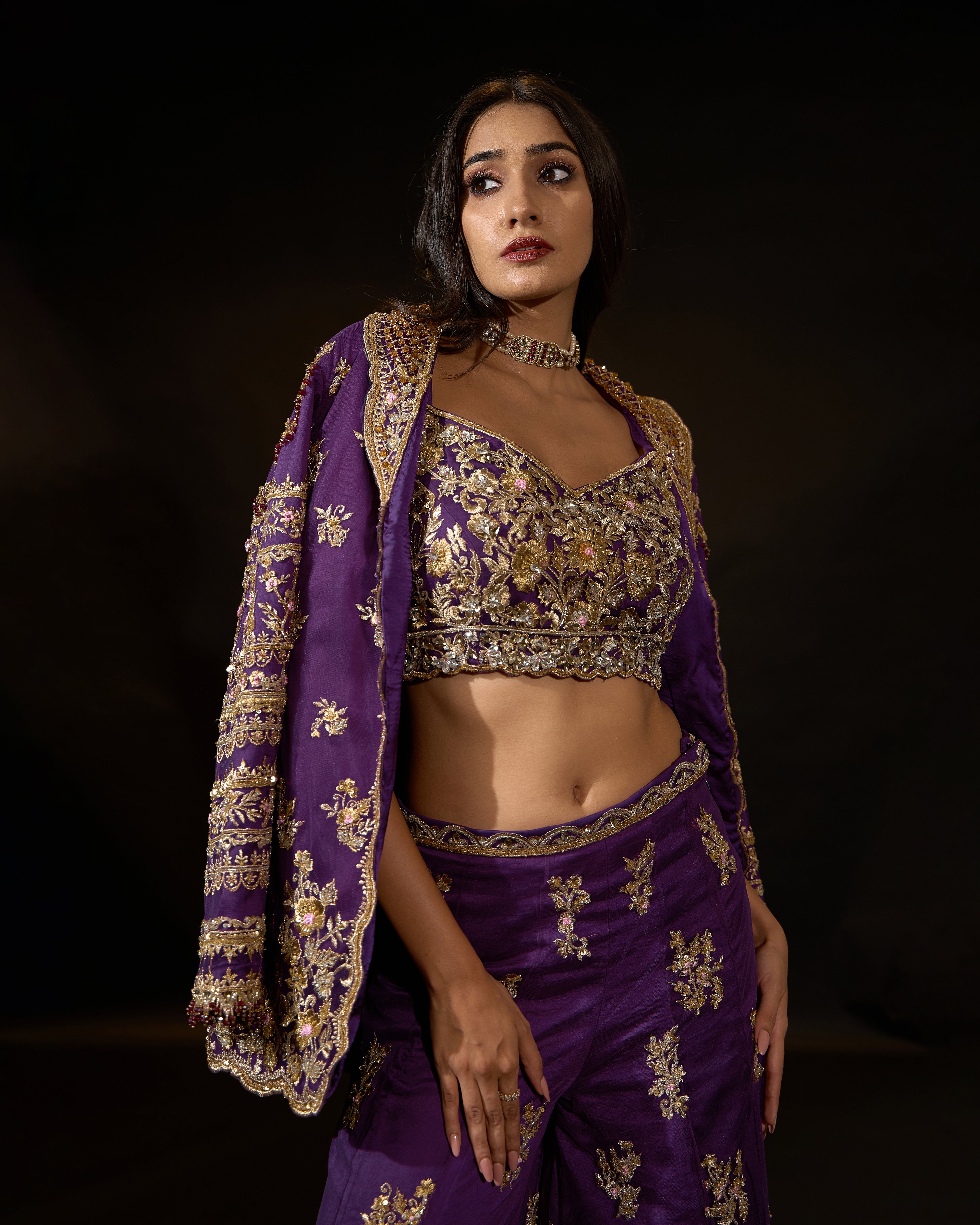 Model Rheyea in a purple jacket dress with bralette and palazzo pants. jacket over shoulder and bralette detailing.