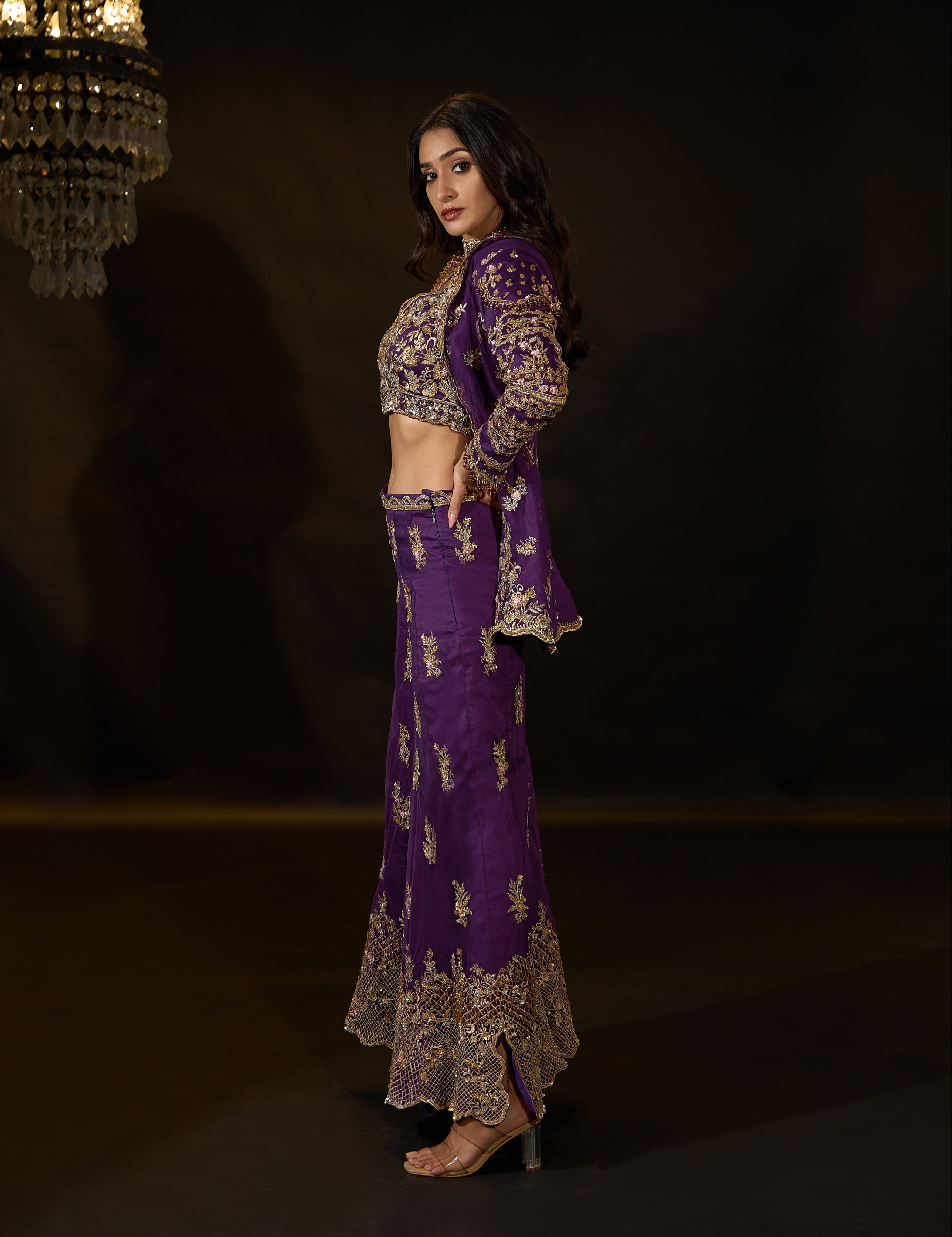 Model Rheyea in a purple jacket dress with bralette and palazzo pants. side profile.