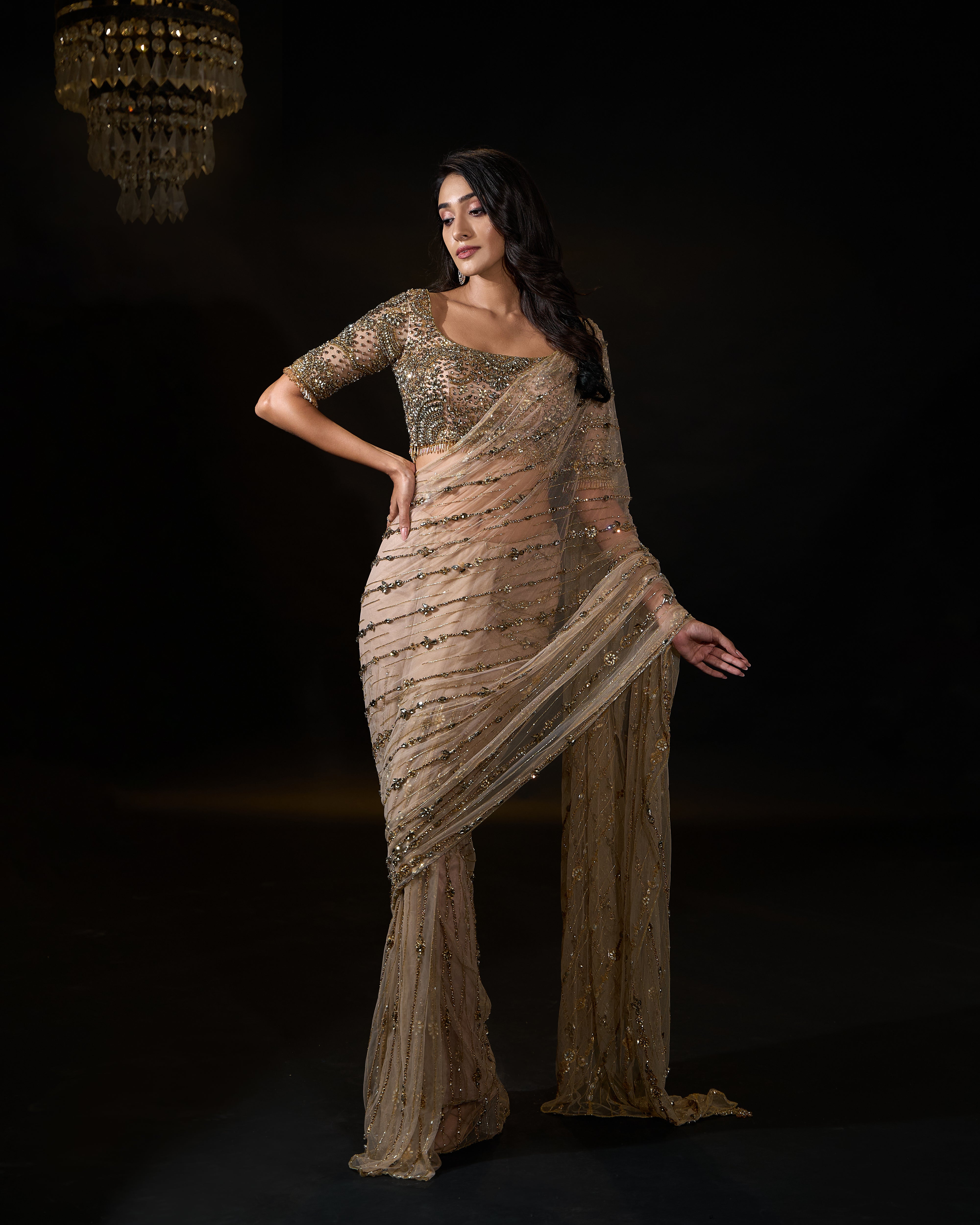 Model Rheyea in signature golden beige handcrafted net saree paired with a heavily embellished blouse by Archana Karthick. Stone work.