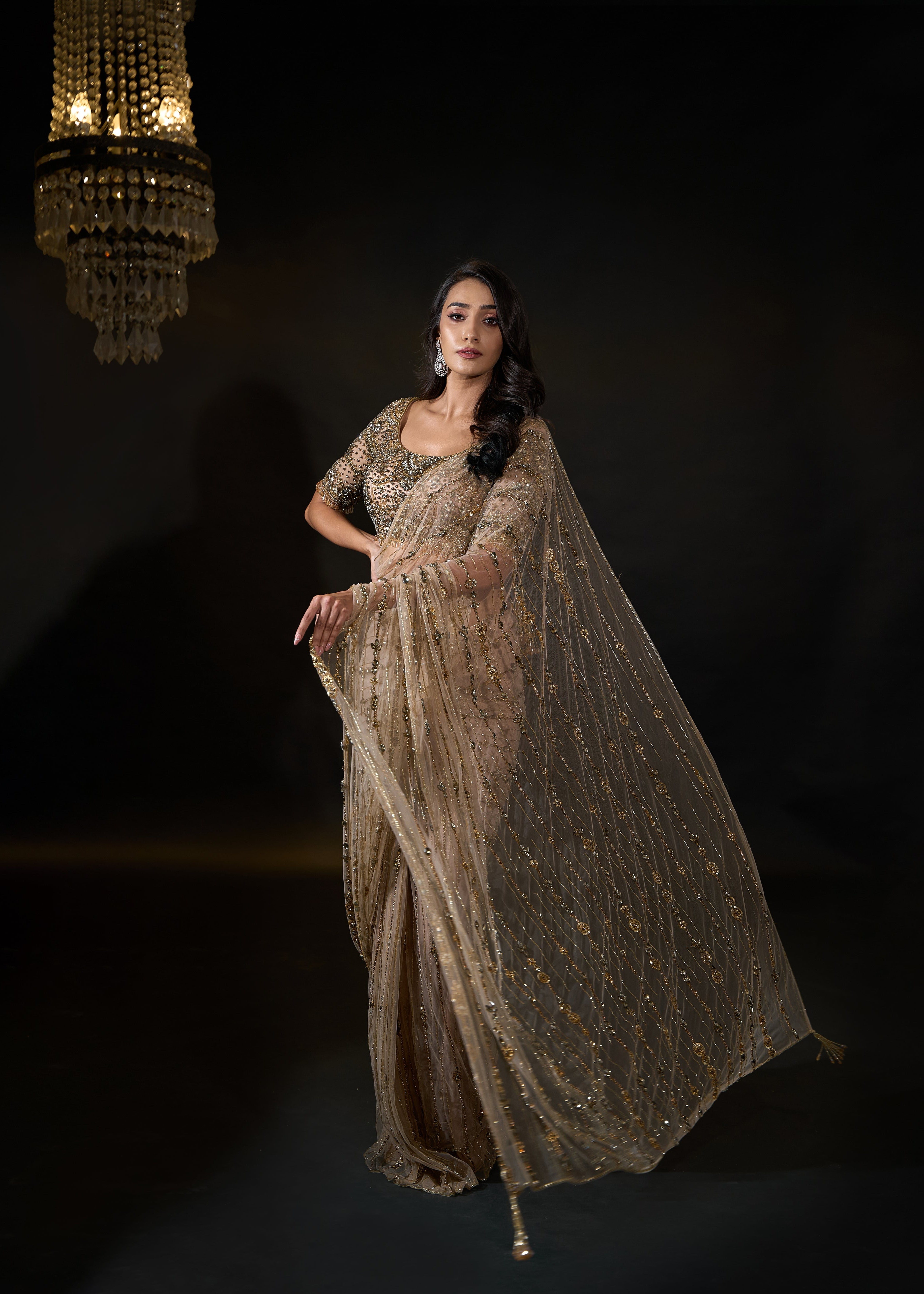 Model Rheyea in signature golden beige handcrafted net saree paired with a heavily embellished blouse by Archana Karthick. Stone work all over pallu.