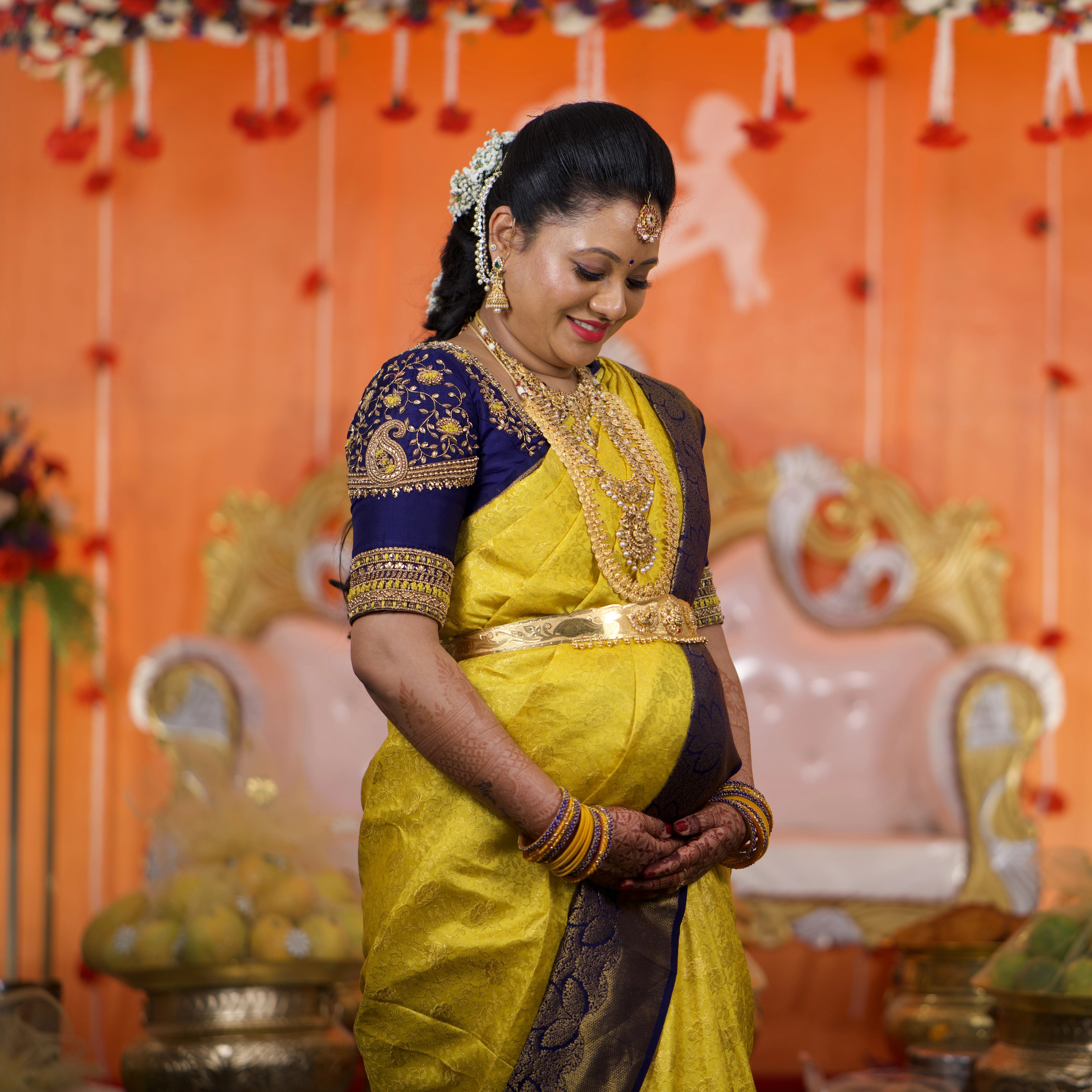 Mom to be from Seattle, USA, smiling in a blue rawsilk blouse designed by Archana Karthick for her baby shower.