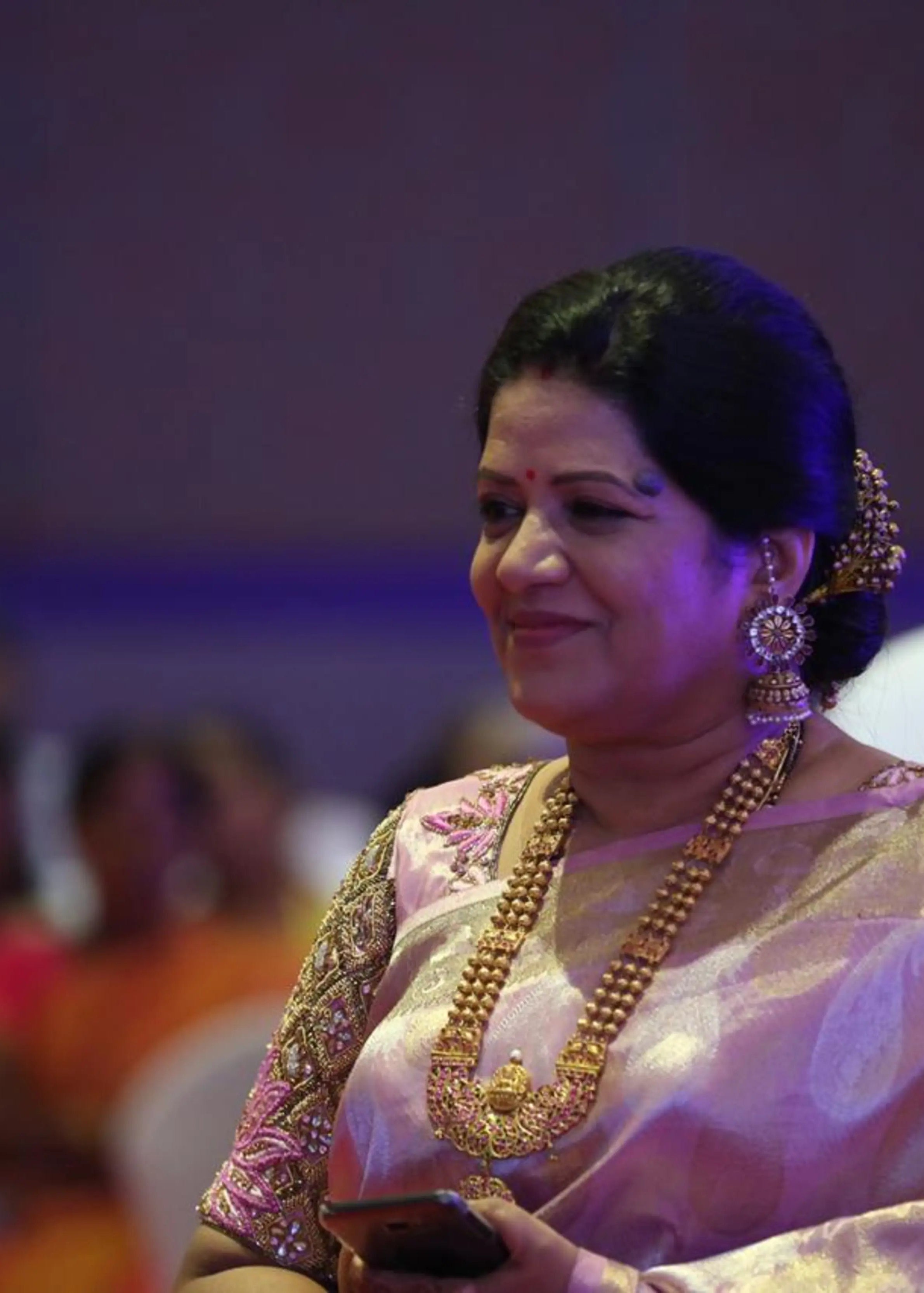 Mother of the bride posing in a pink silk blouse, handcrafted by team Archana Karthick.