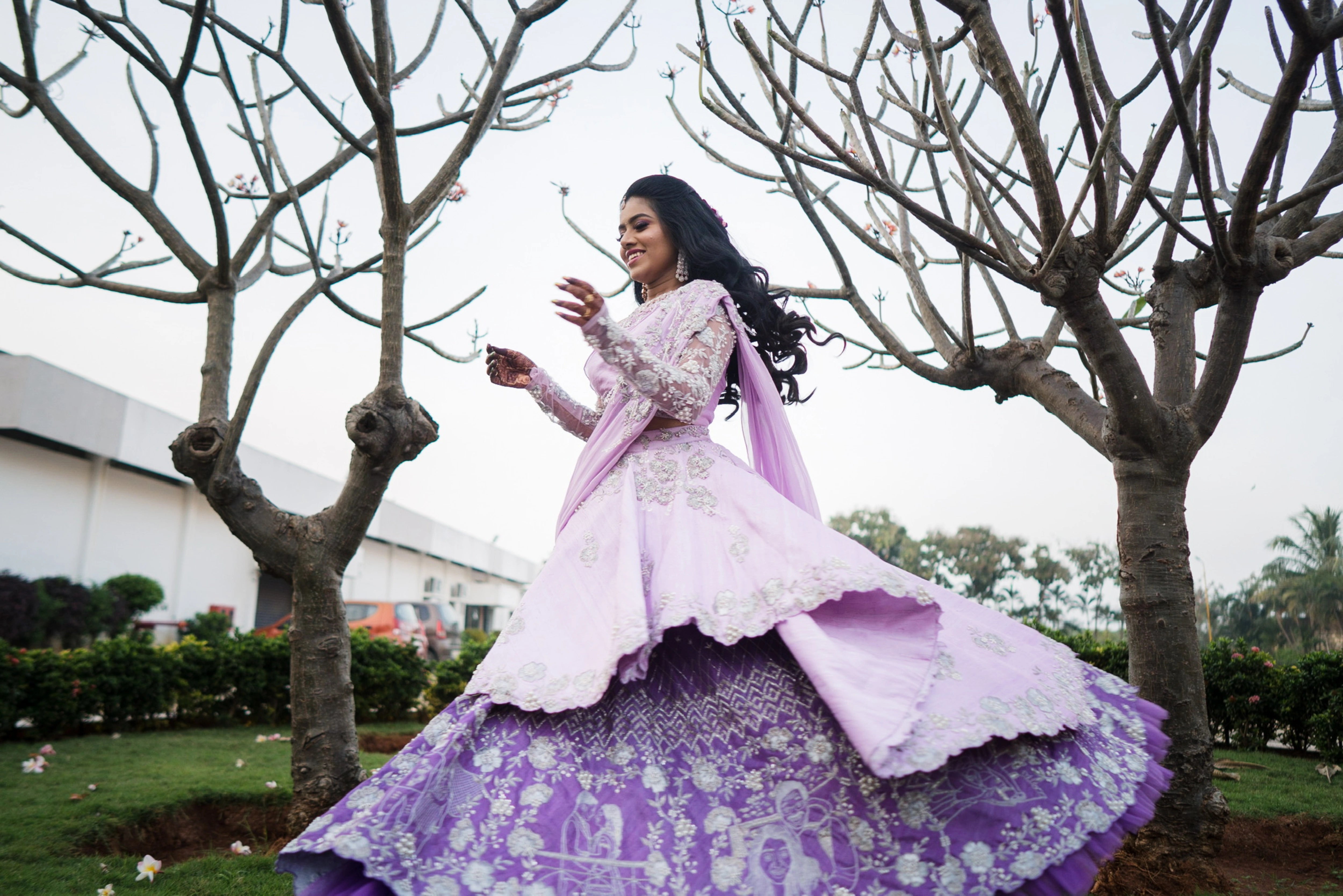 Nisha posing in a lilac raw silk one-shoulder lehenga handcrafted by team Archana Karthick.