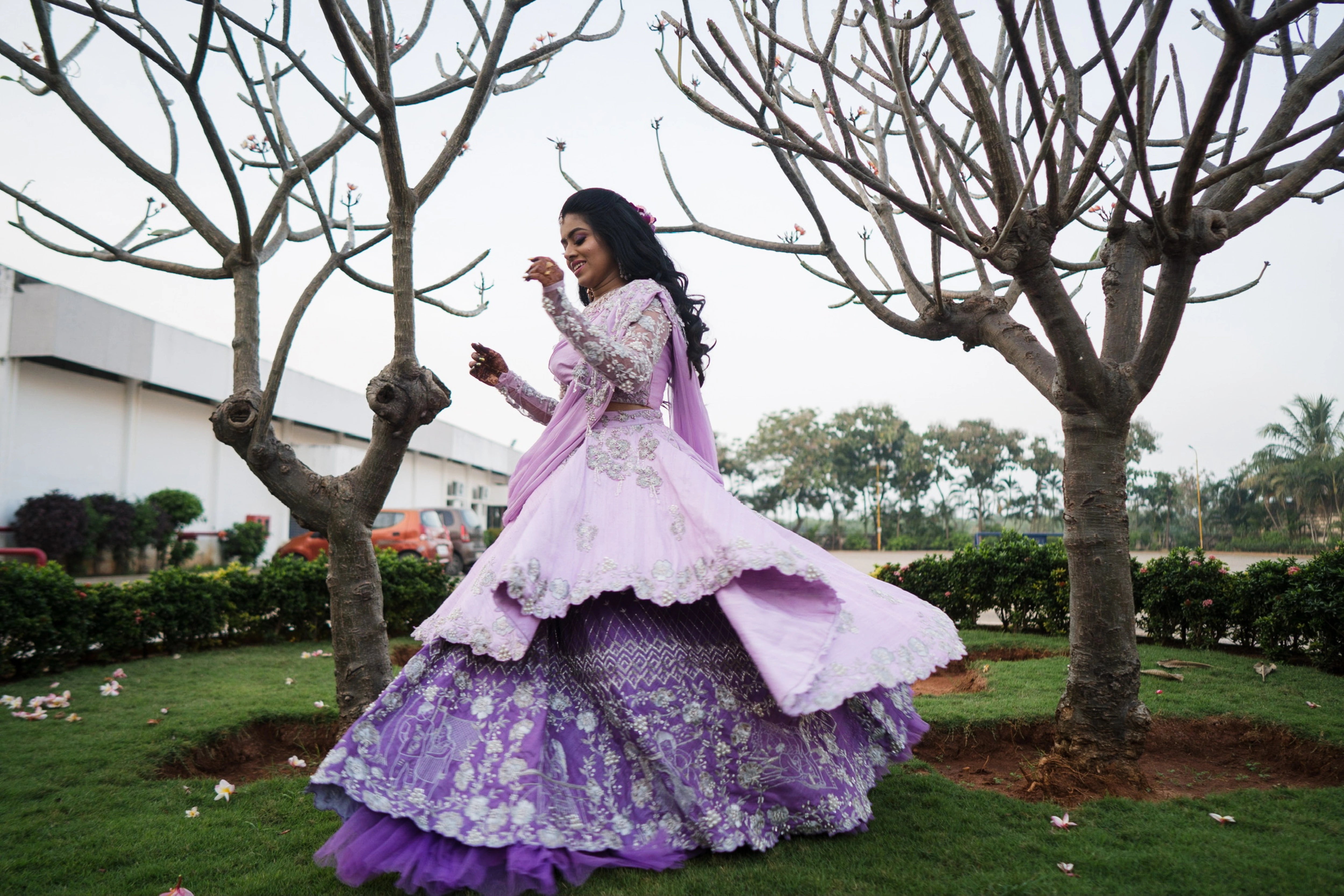 Nisha twirling in a lilac raw silk one-shoulder lehenga handcrafted by team Archana Karthick.
