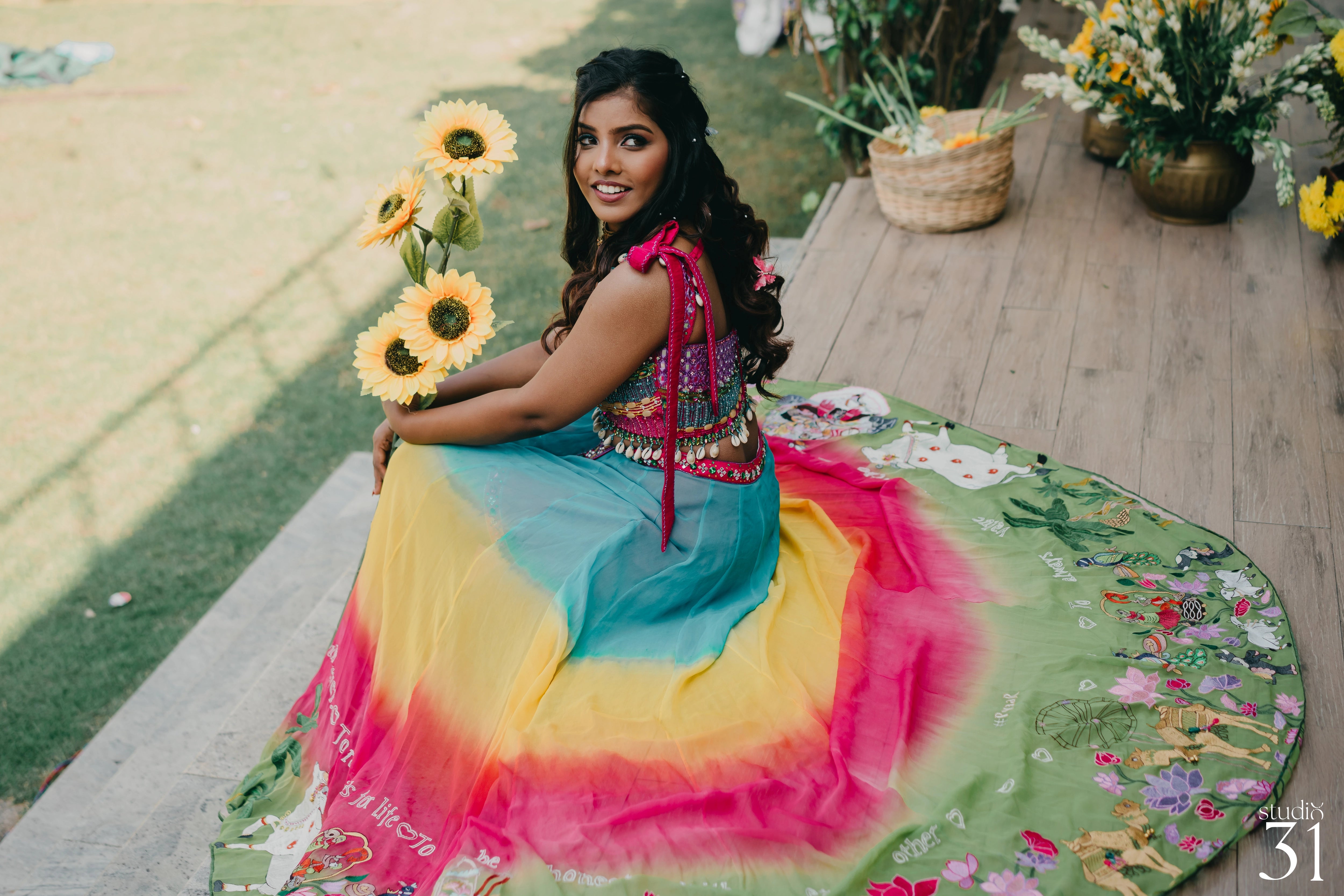 Pooja in a multi-colored fusion lehenga for her mehendi, dyed and intricately handcrafted by team Archana Karthick.