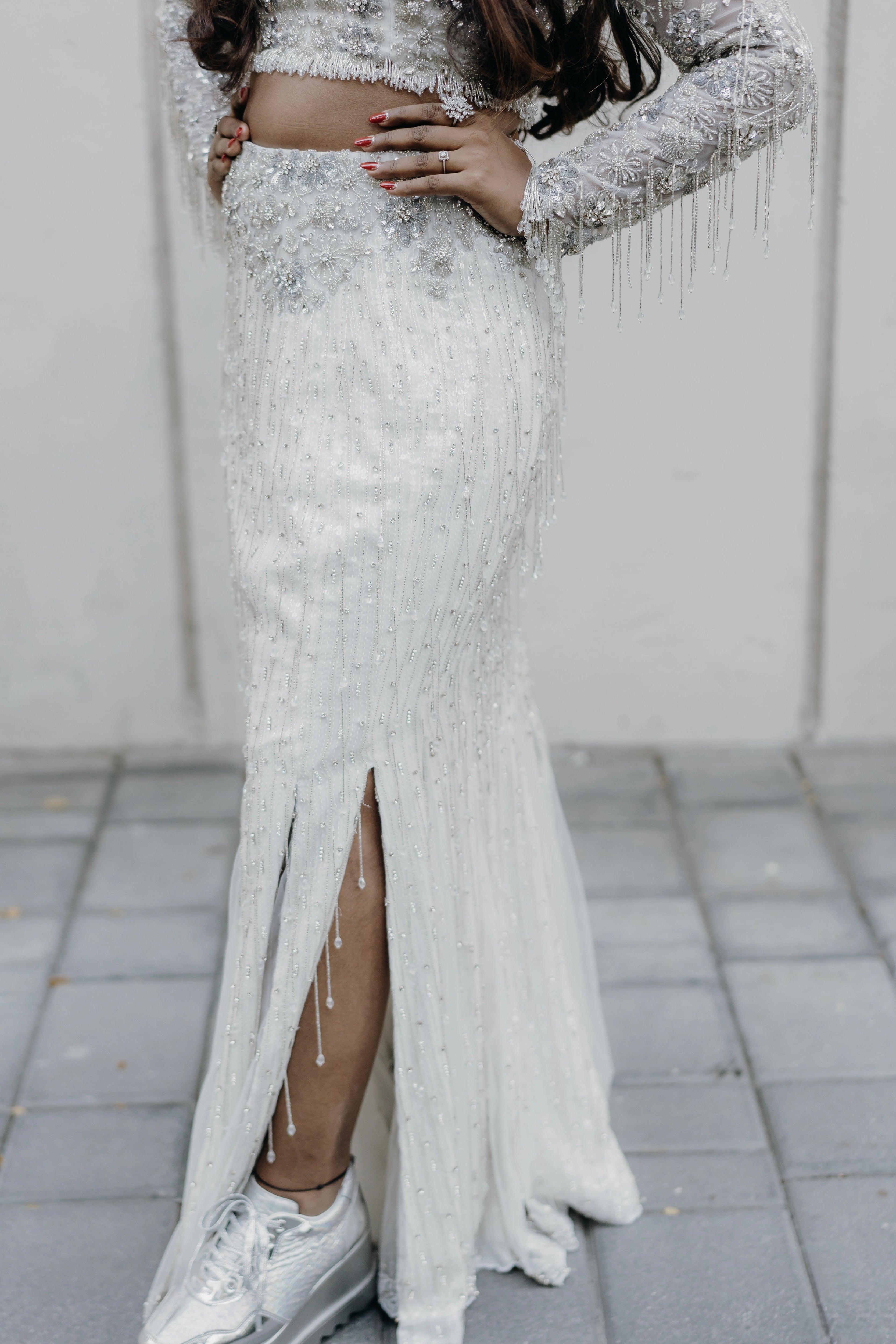 Pooja posing for photo in a fusion lehenga for her sangeet intricately handcrafted by team Archana Karthick.