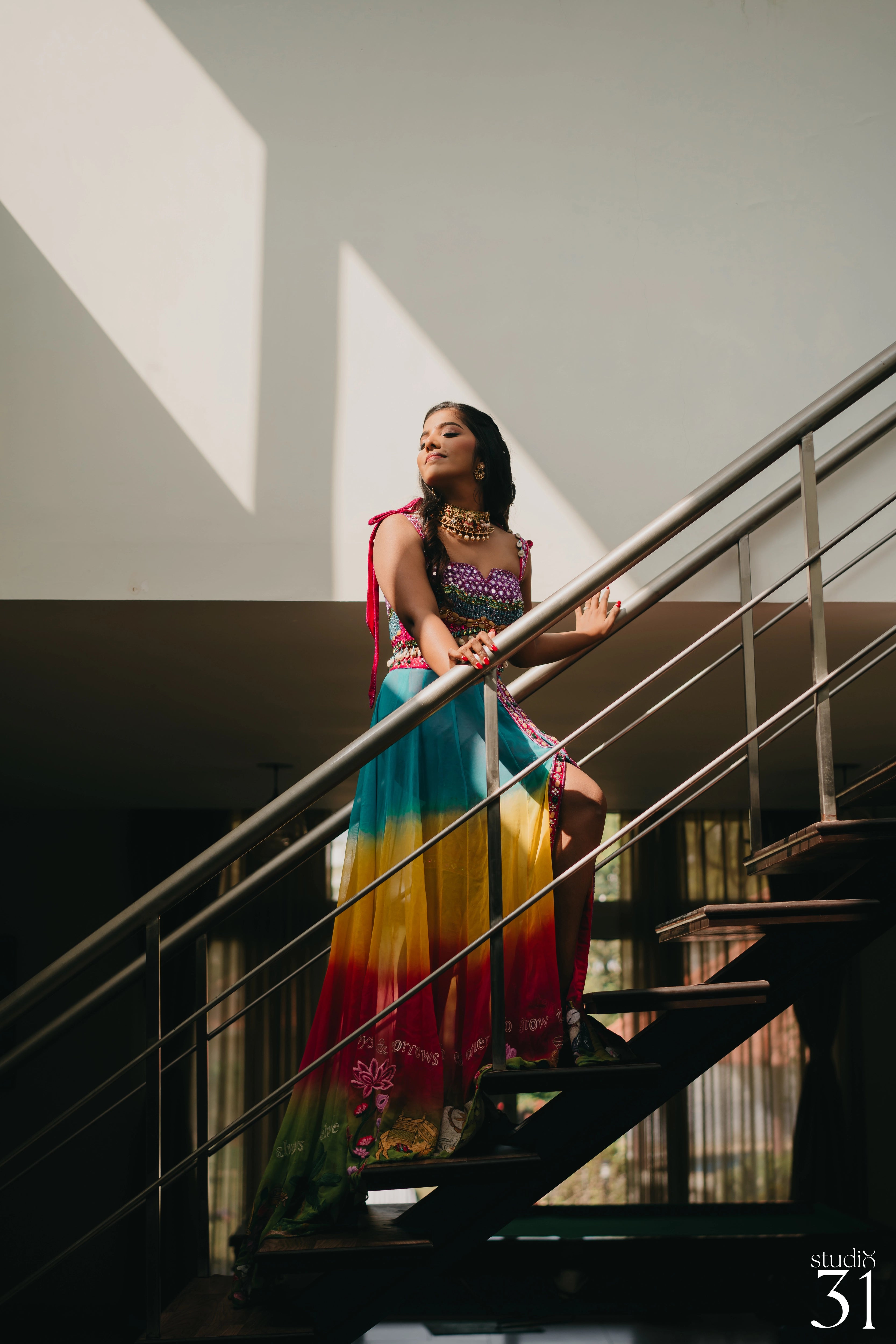 Pooja posing for shoot in a multi-colored fusion lehenga for her mehendi, dyed and intricately handcrafted by team Archana Karthick.