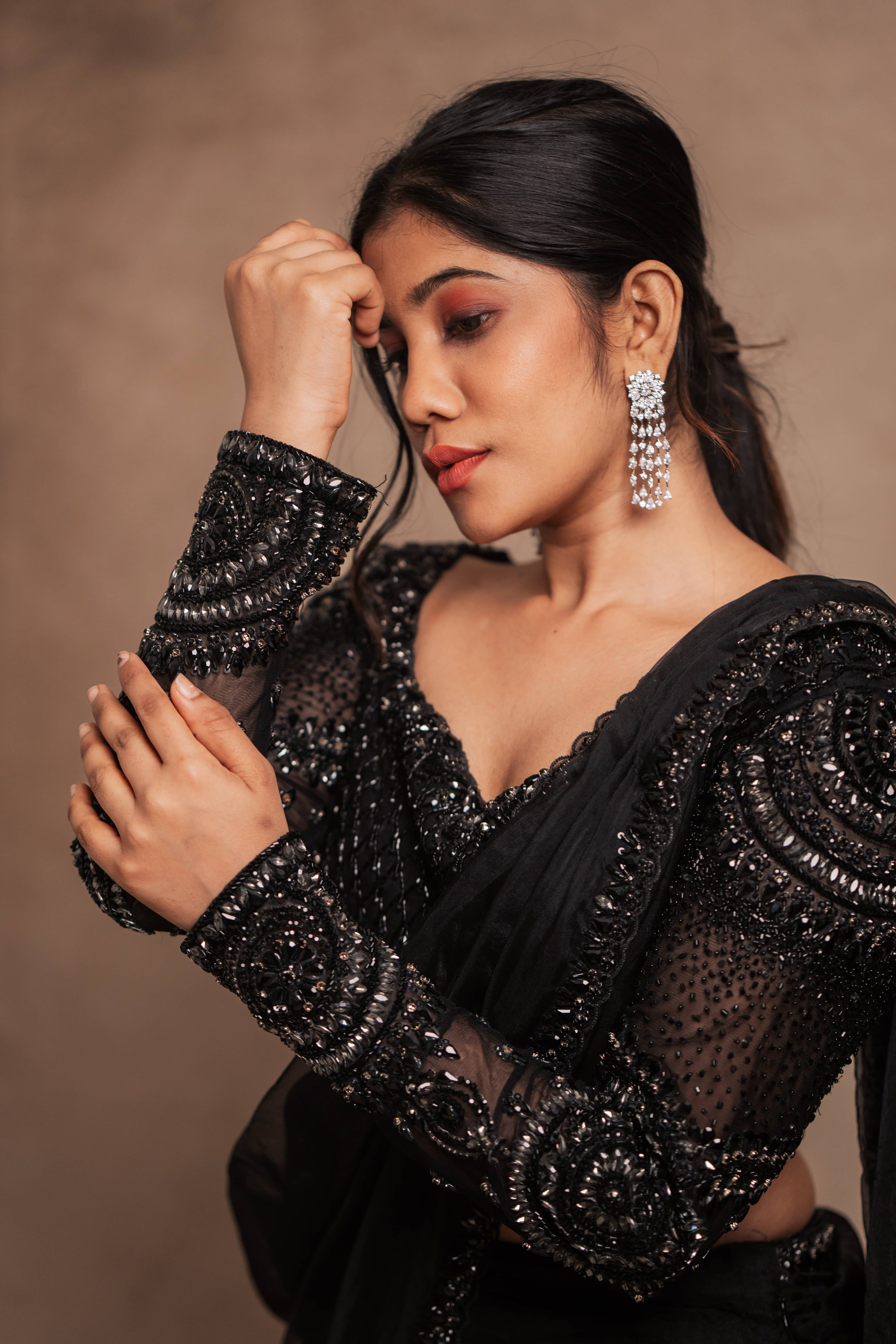 Posing in a black organza mermaid saree intricately handcrafted with stones, crystals, and sequins designed by team Archana Karthick.