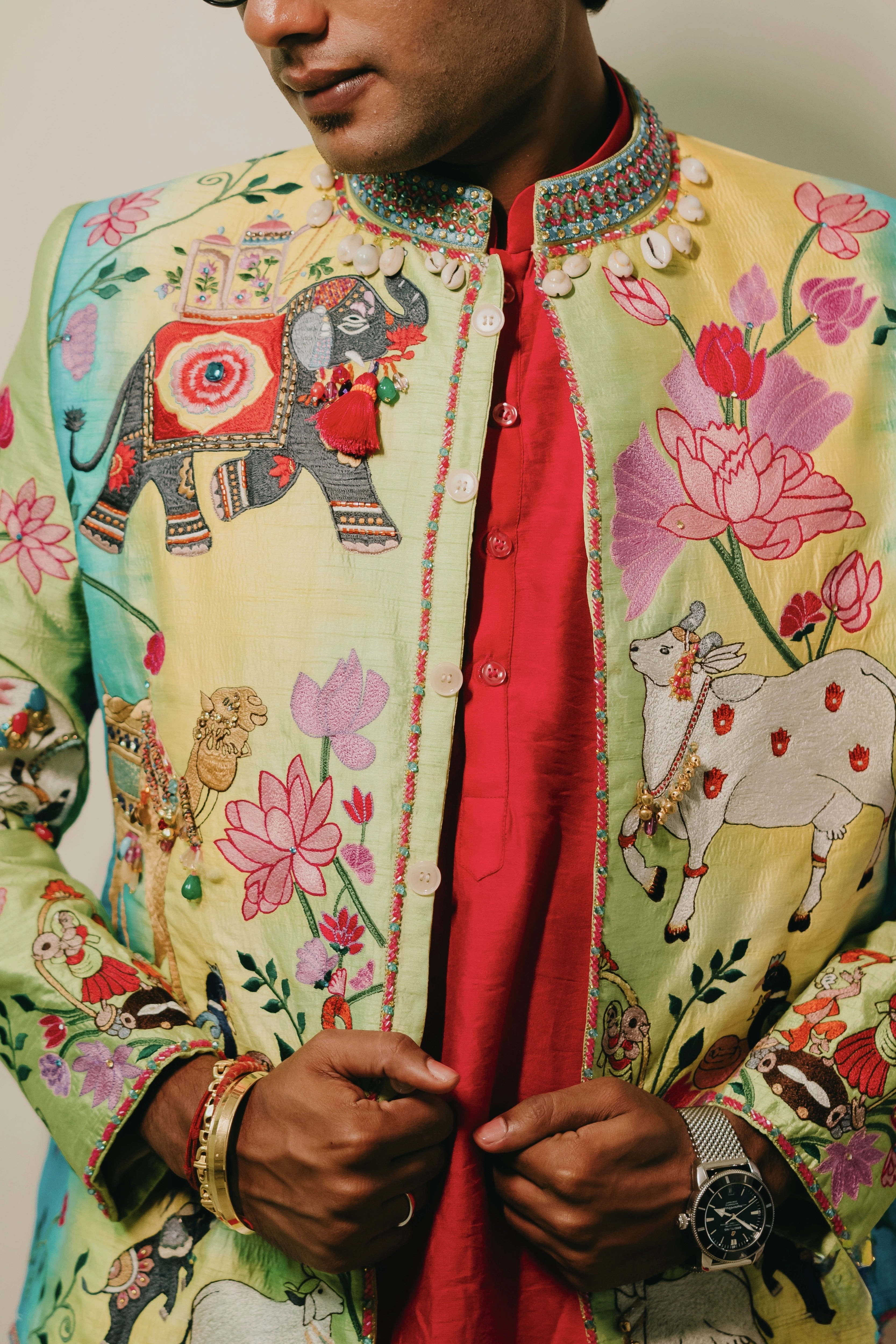 Rhevanth posing in a multi-colored fusion bandhgala for his mehendi, dyed and intricately handcrafted by team Archana Karthick.