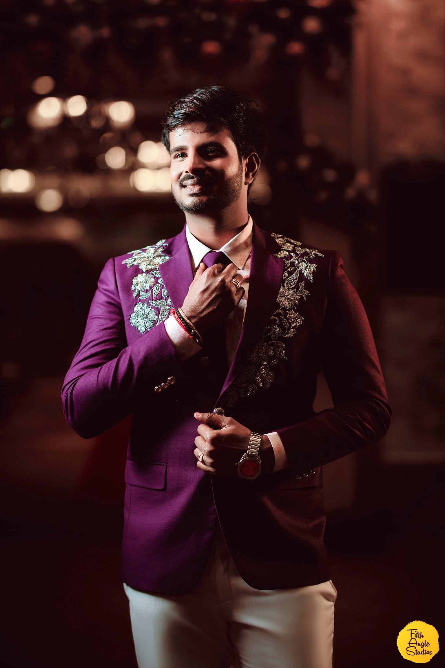 Sai Sridevi's Groom posing in a purple gown and suit handcrafted by team Archana Karthick.