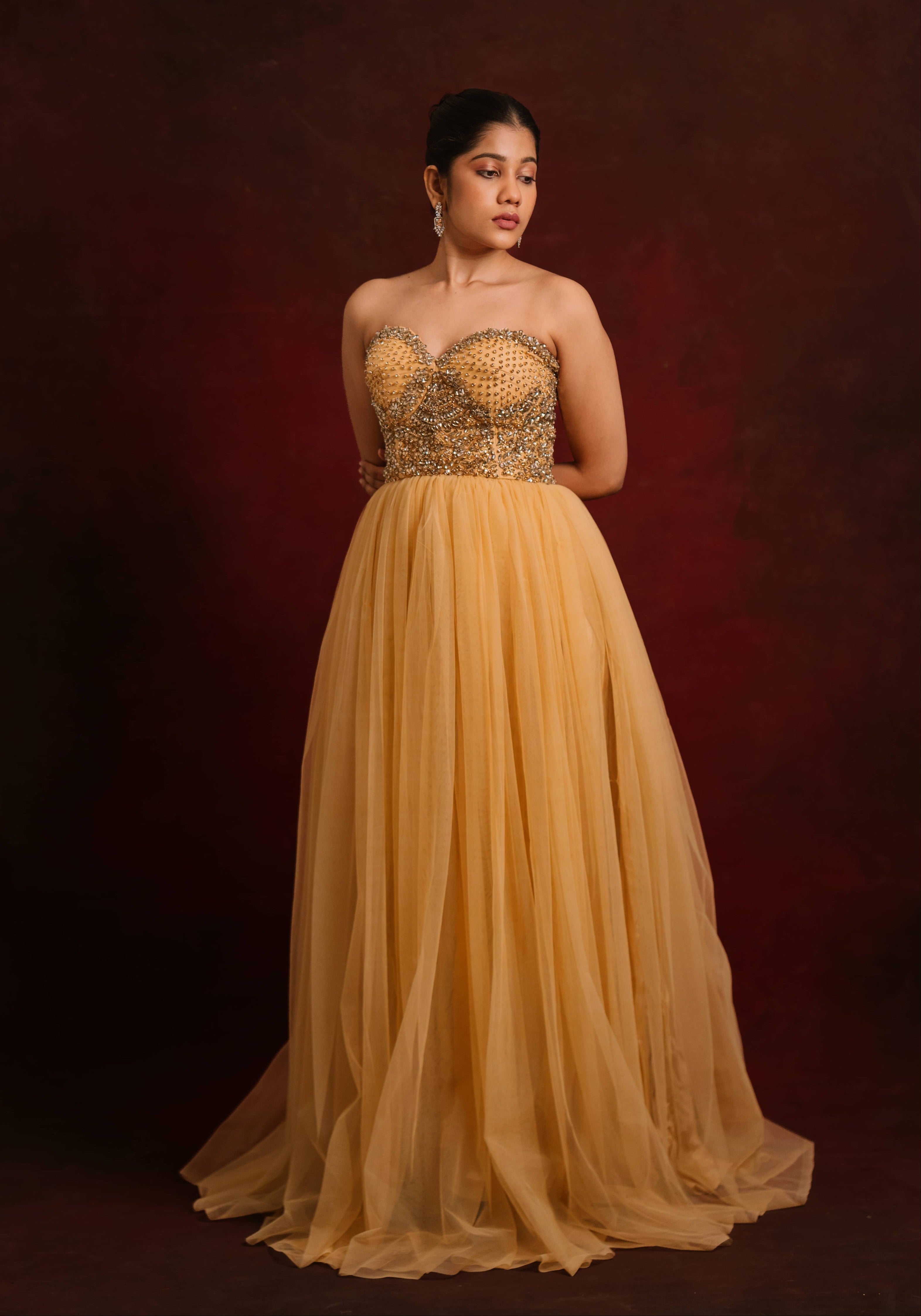 Showcasing a gold corset dress intricately handcrafted with stones and sequins designed by team Archana Karthick.