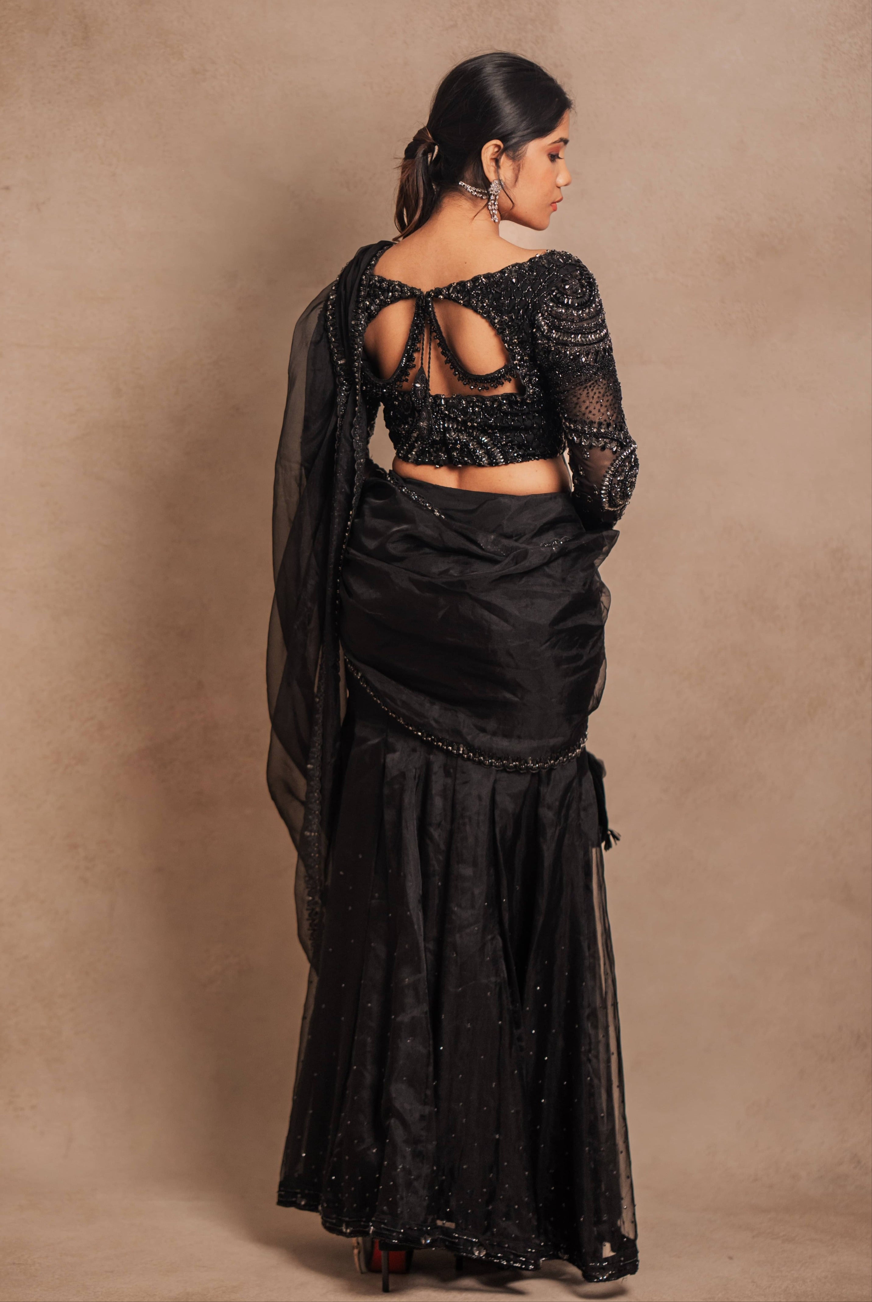 Showcasing back details in a black organza mermaid saree intricately handcrafted with stones, crystals, and sequins designed by team Archana Karthick.