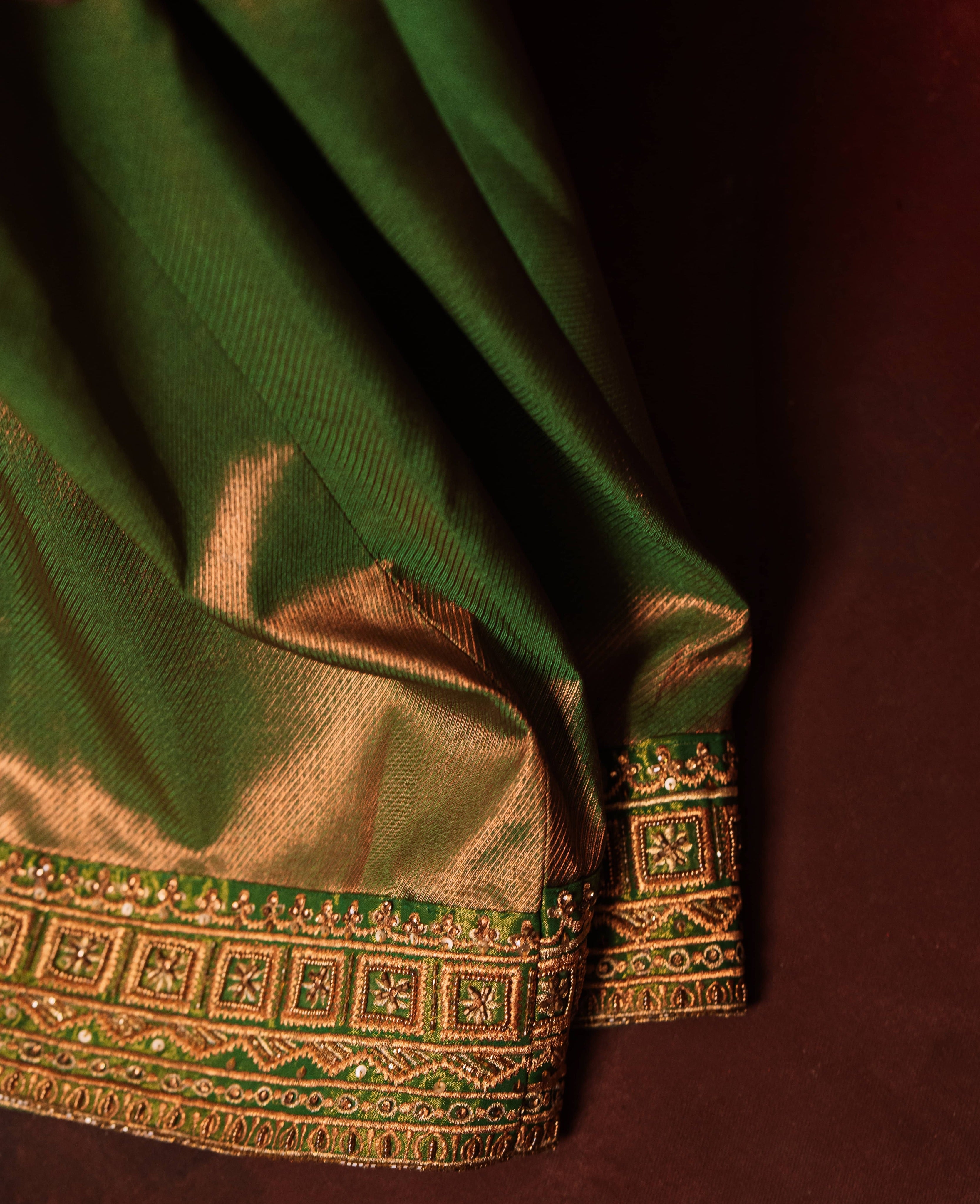 Showcasing border of a silk corset designer dress intricately handcrafted with zari, gold beads, and antique cutdana by team Archana Karthick.