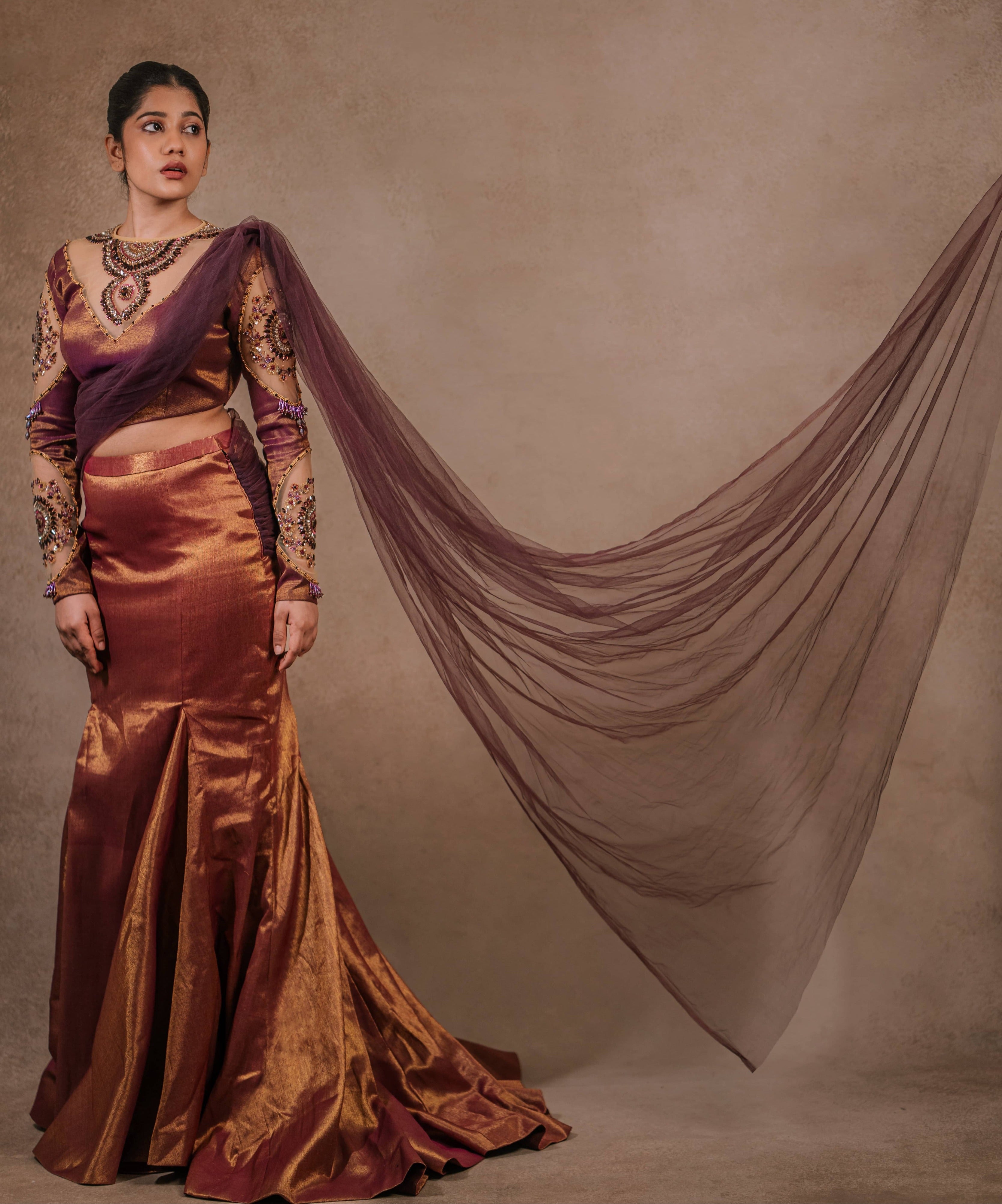 Showcasing dupatta detailings of a tissue lehenga with a mermaid skirt & a tulle dupatta intricately handcrafted with stones, crystals, and sequins by team Archana Karthick.