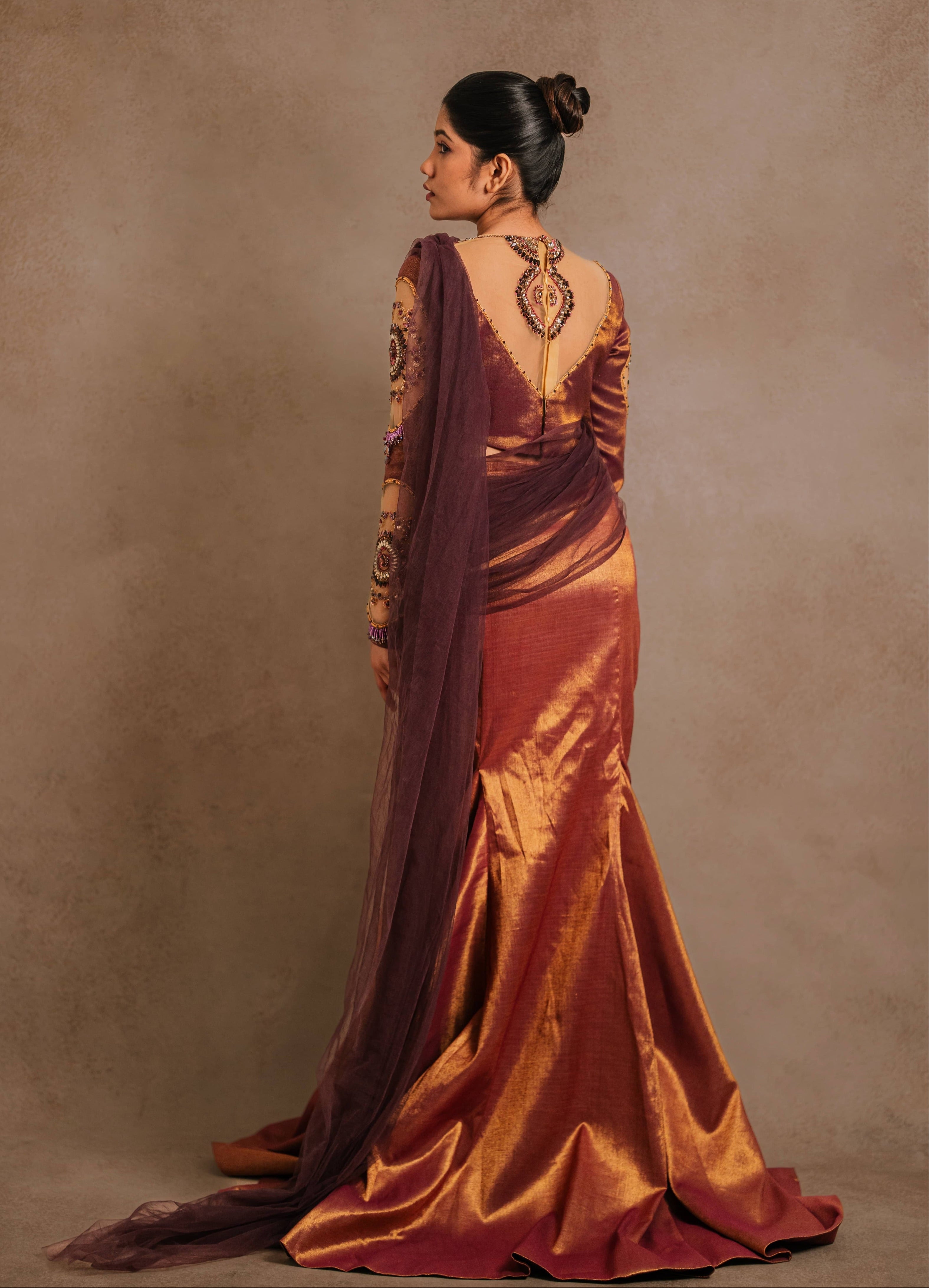 Showcasing full back profile detailings of a tissue lehenga with a mermaid skirt & a tulle dupatta intricately handcrafted with stones, crystals, and sequins by team Archana Karthick.