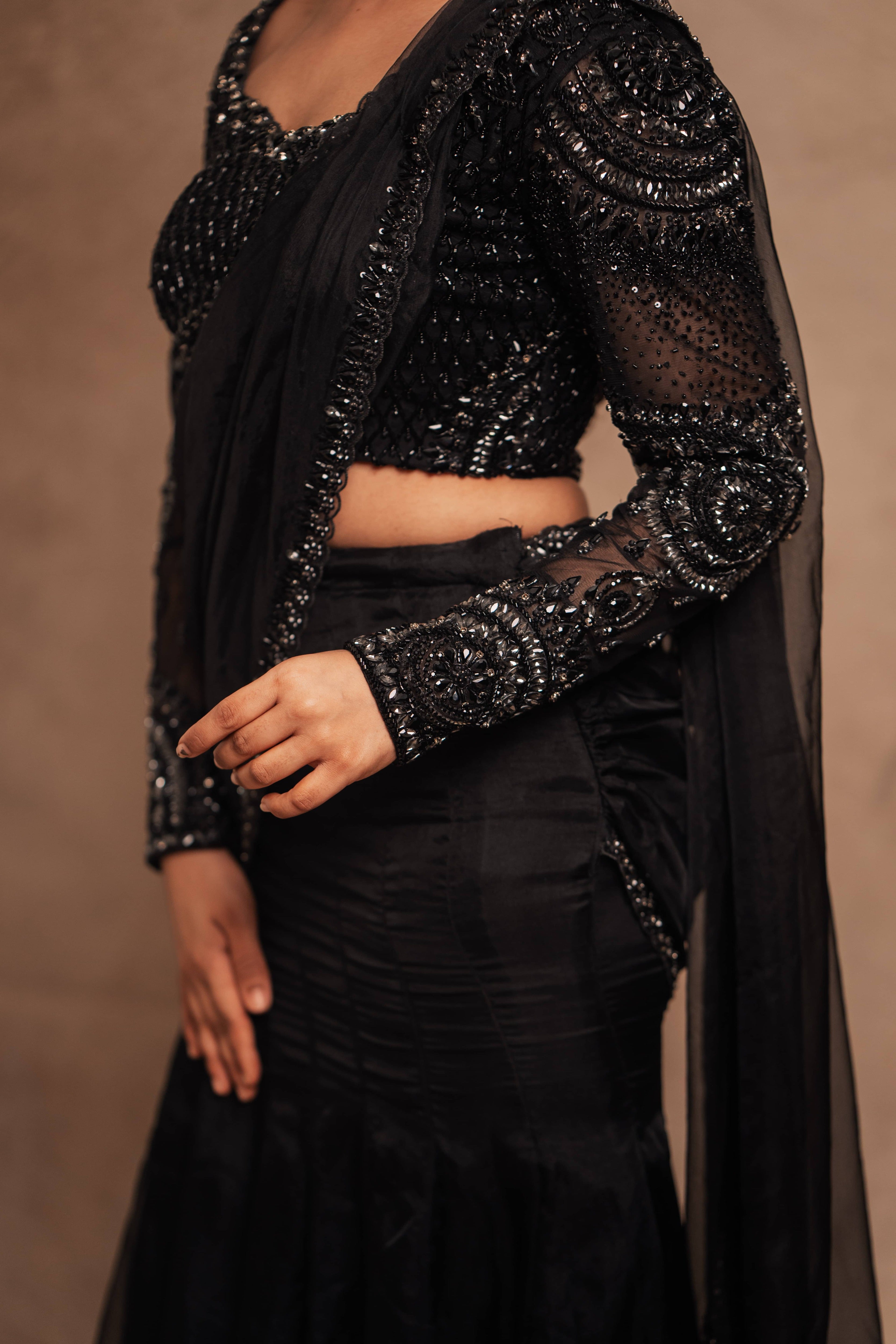 Showcasing side design details in a black organza mermaid saree intricately handcrafted with stones, crystals, and sequins designed by team Archana Karthick.