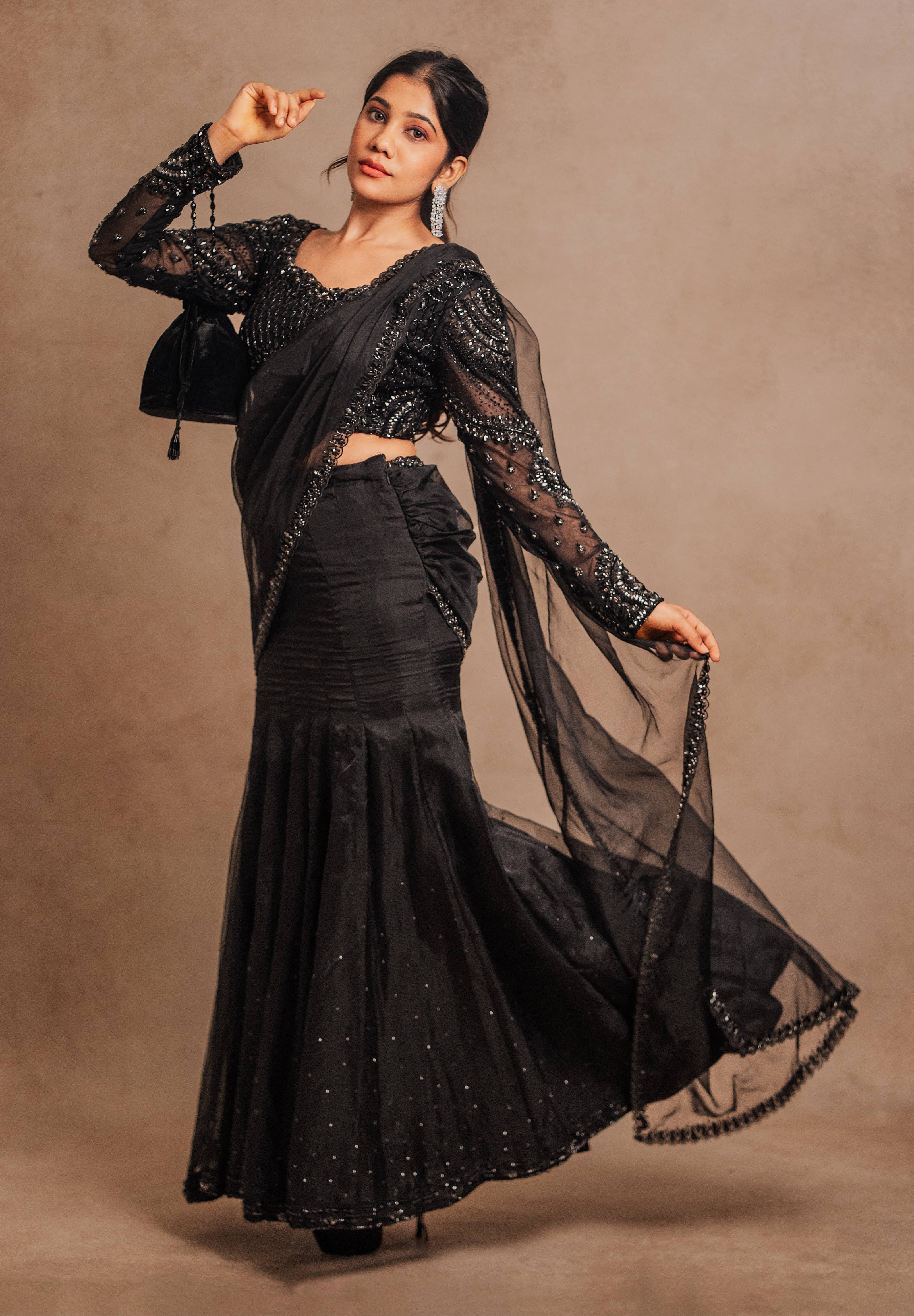 Showcasing silhouette details in a black organza mermaid saree intricately handcrafted with stones, crystals, and sequins designed by team Archana Karthick.