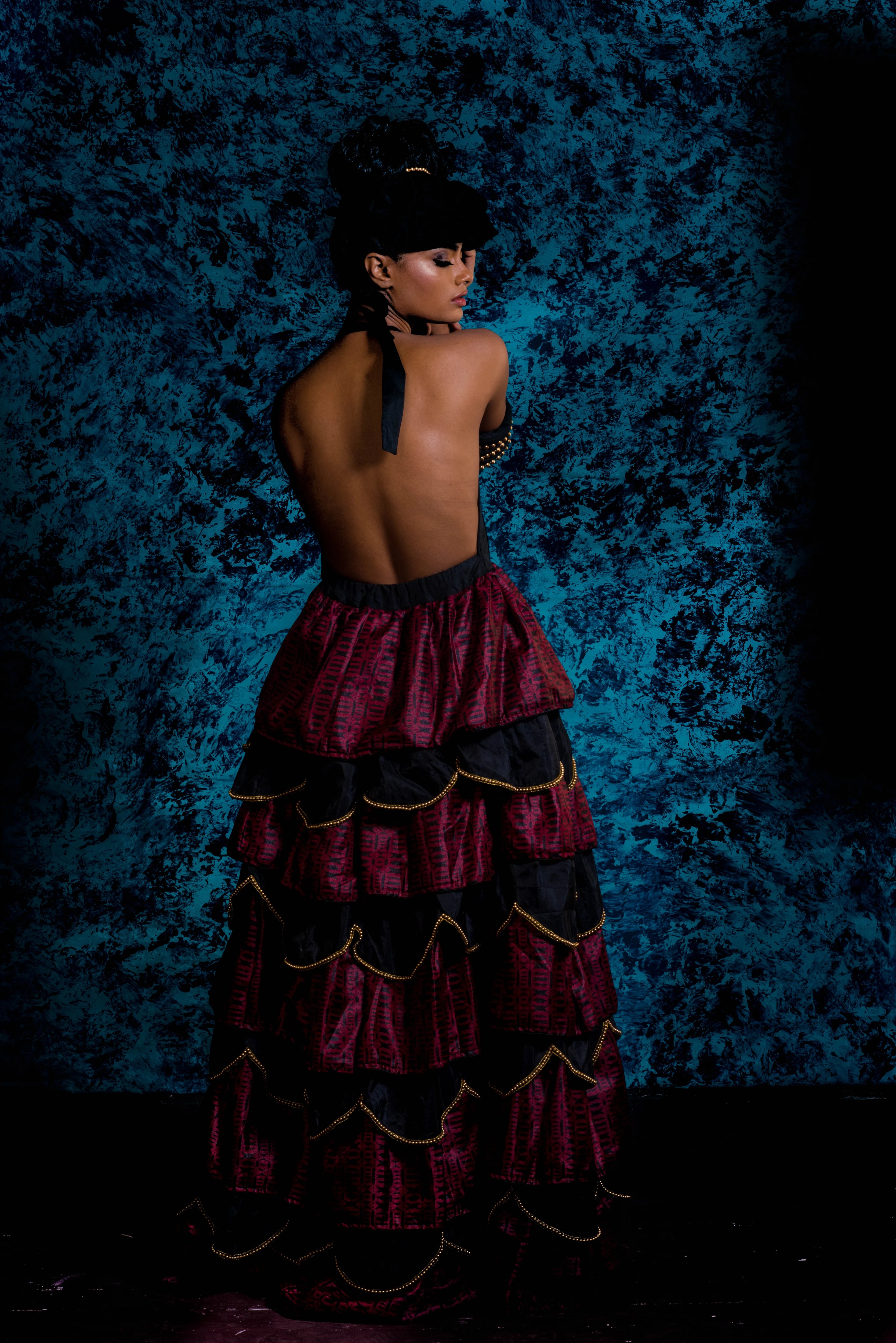 Supermodel Archana Akil Kumar posing for back design in a noir halterneck gown with a multi-tiered scalloped look. Partywear Gown.