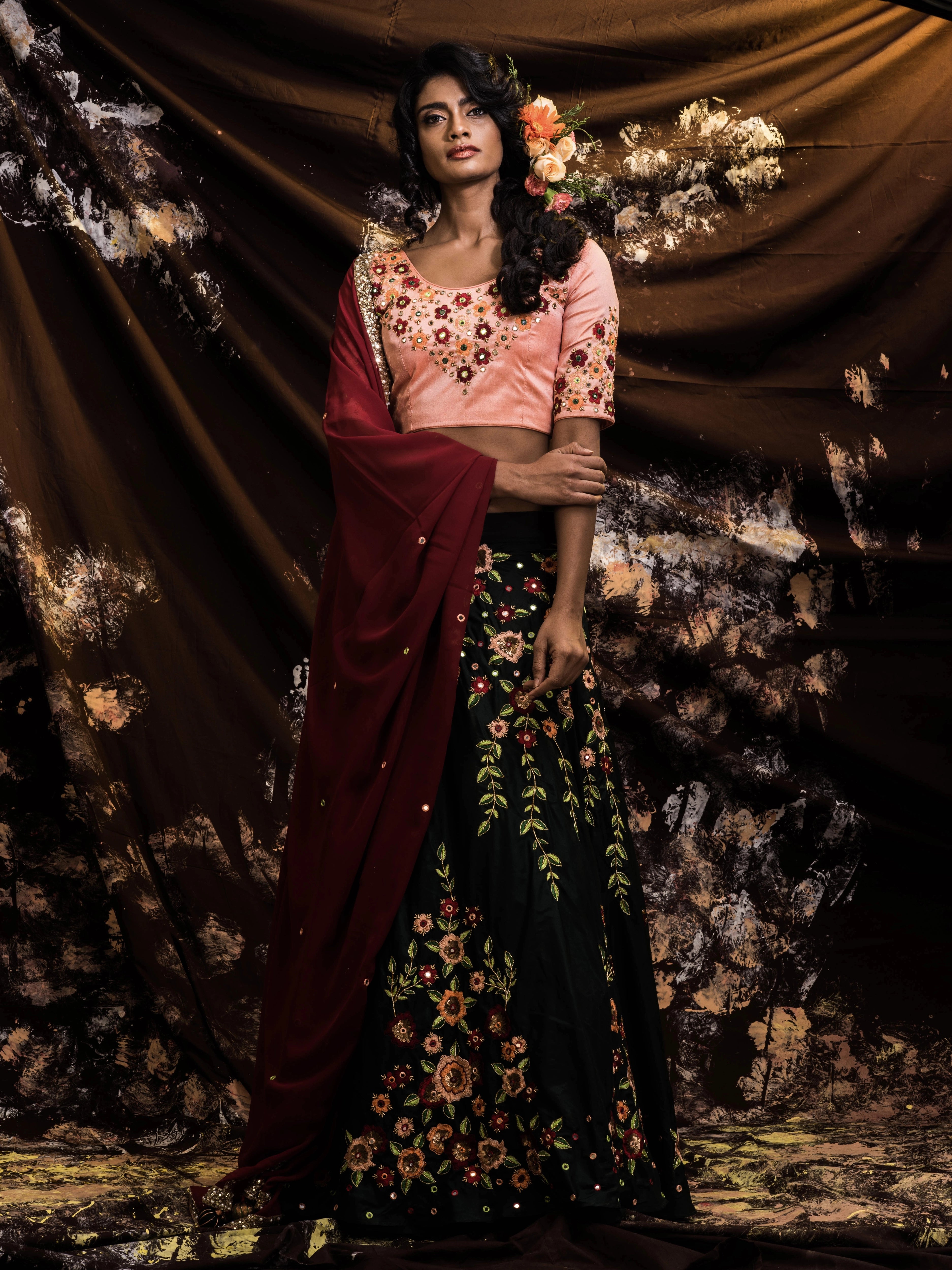 Supermodel Archana Akil Kumar posing in a rawsilk peach and bottle green lehenga with a maroon georgette dupatta intricately handcrafted by team Archana Karthick.