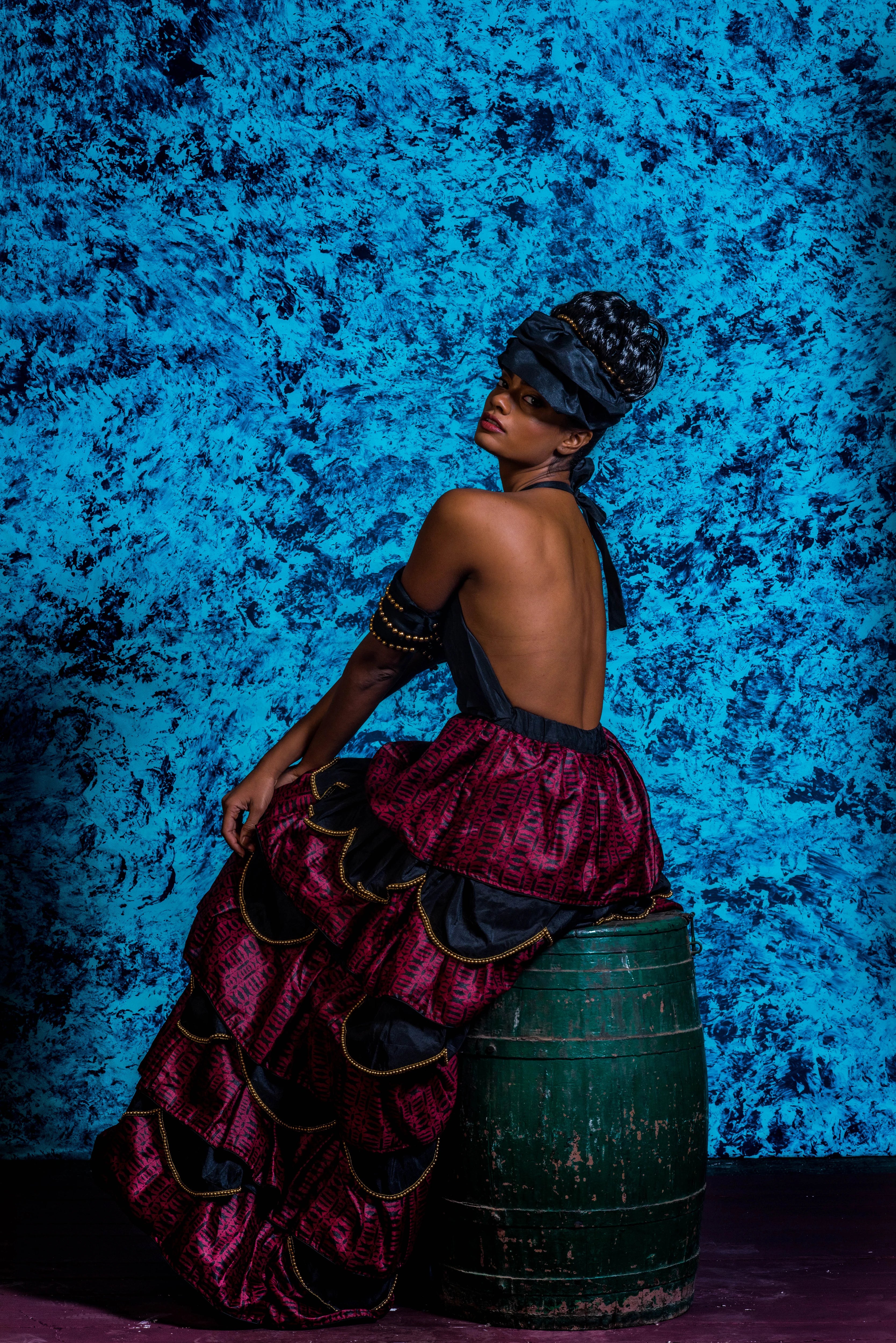 Supermodel Archana Akil Kumar posing on a cask in a noir halterneck gown with a multi-tiered scalloped look. Partywear Gown.